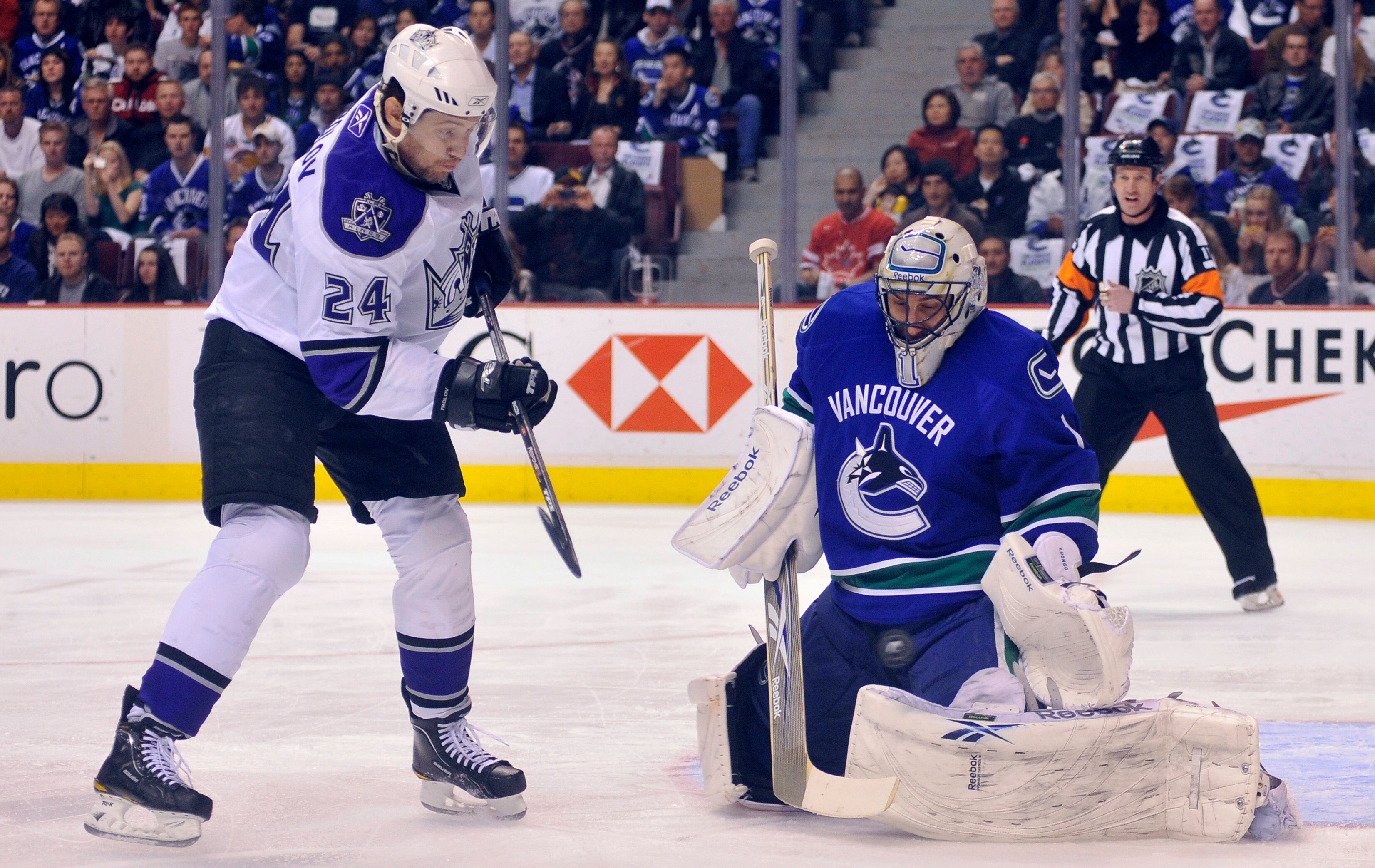 VANCOUVER, CANADA - APRIL 15: Goalie Roberto Luongo #1 of the Vancouver Canucks makes a pad save while Alexander Frolov #24 of the Los Angeles Kings looks for a rebound in Game One of the Western Conference Quarterfinals during the 2010 NHL Stanley Cup Pl