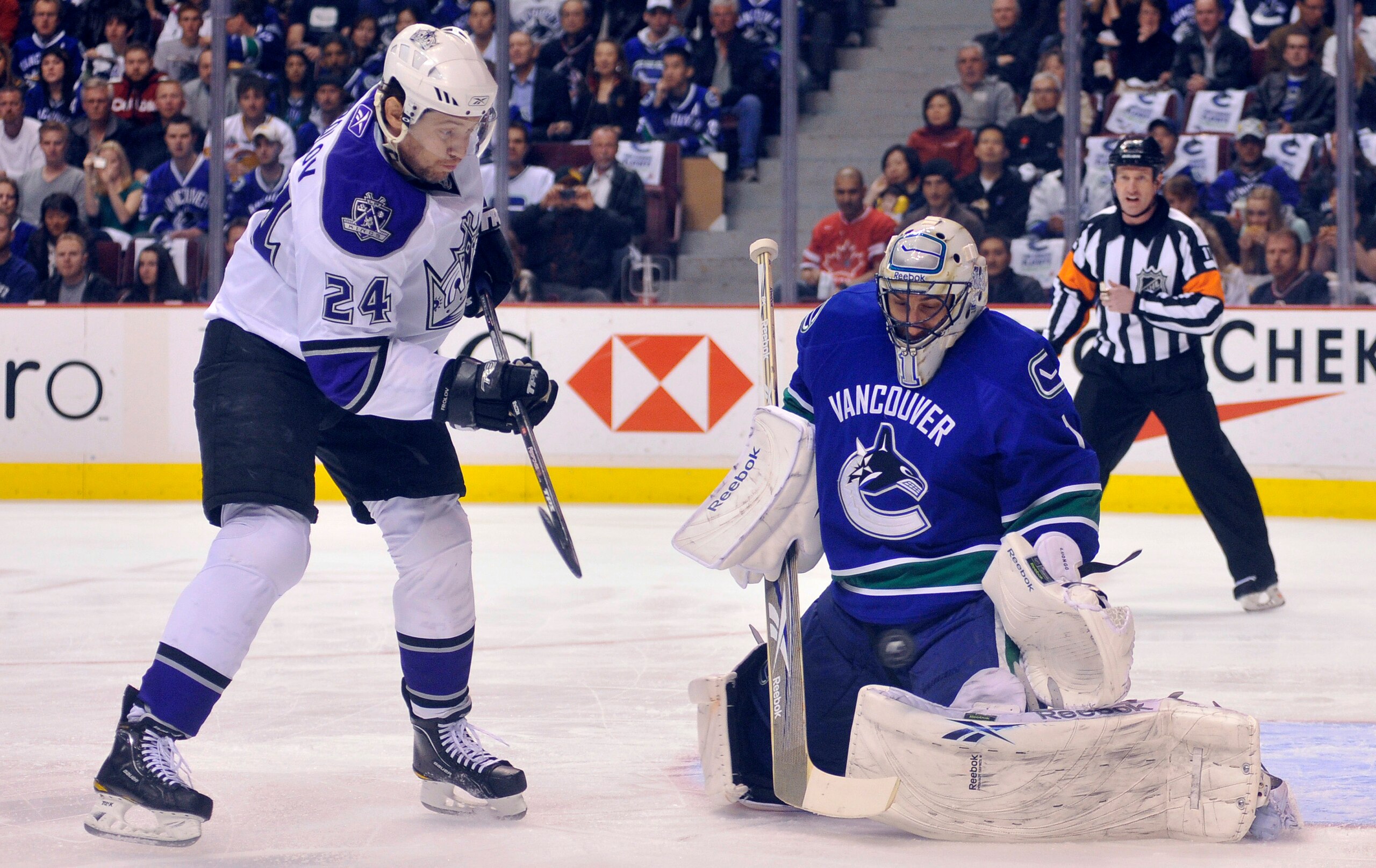 VANCOUVER, CANADA - APRIL 15: Goalie Roberto Luongo #1 of the Vancouver Canucks makes a pad save while Alexander Frolov #24 of the Los Angeles Kings looks for a rebound in Game One of the Western Conference Quarterfinals during the 2010 NHL Stanley Cup Pl