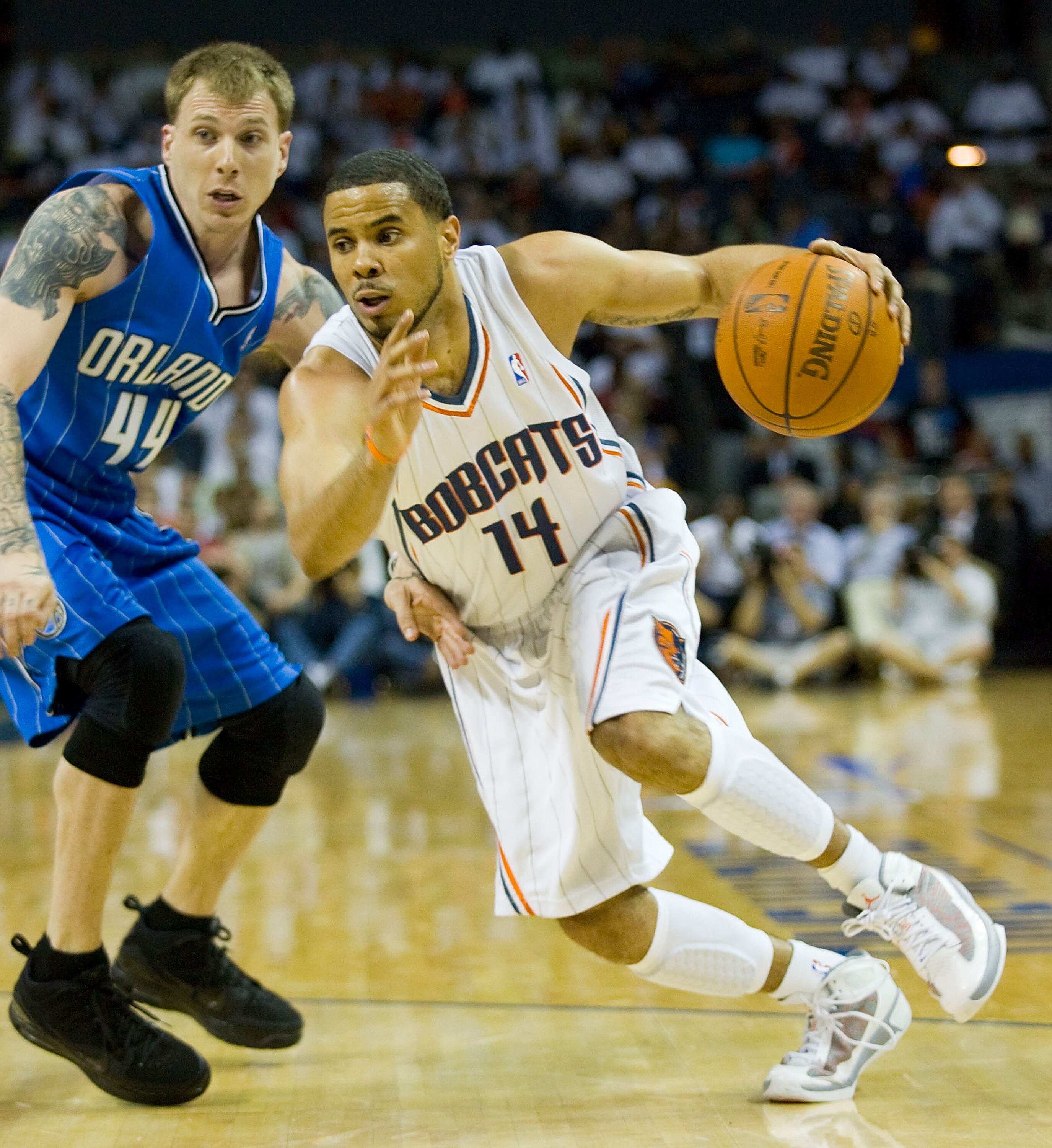 CHARLOTTE, NC - APRIL 26:  D.J. Augustin #14 of the Charlotte Bobcats dribbles past Jason Williams #44 of the Orlando Magic in Game Four of the Eastern Conference Quarterfinals during the 2010 NBA Playoffs at Time Warner Cable Arena on April 26, 2010 in C