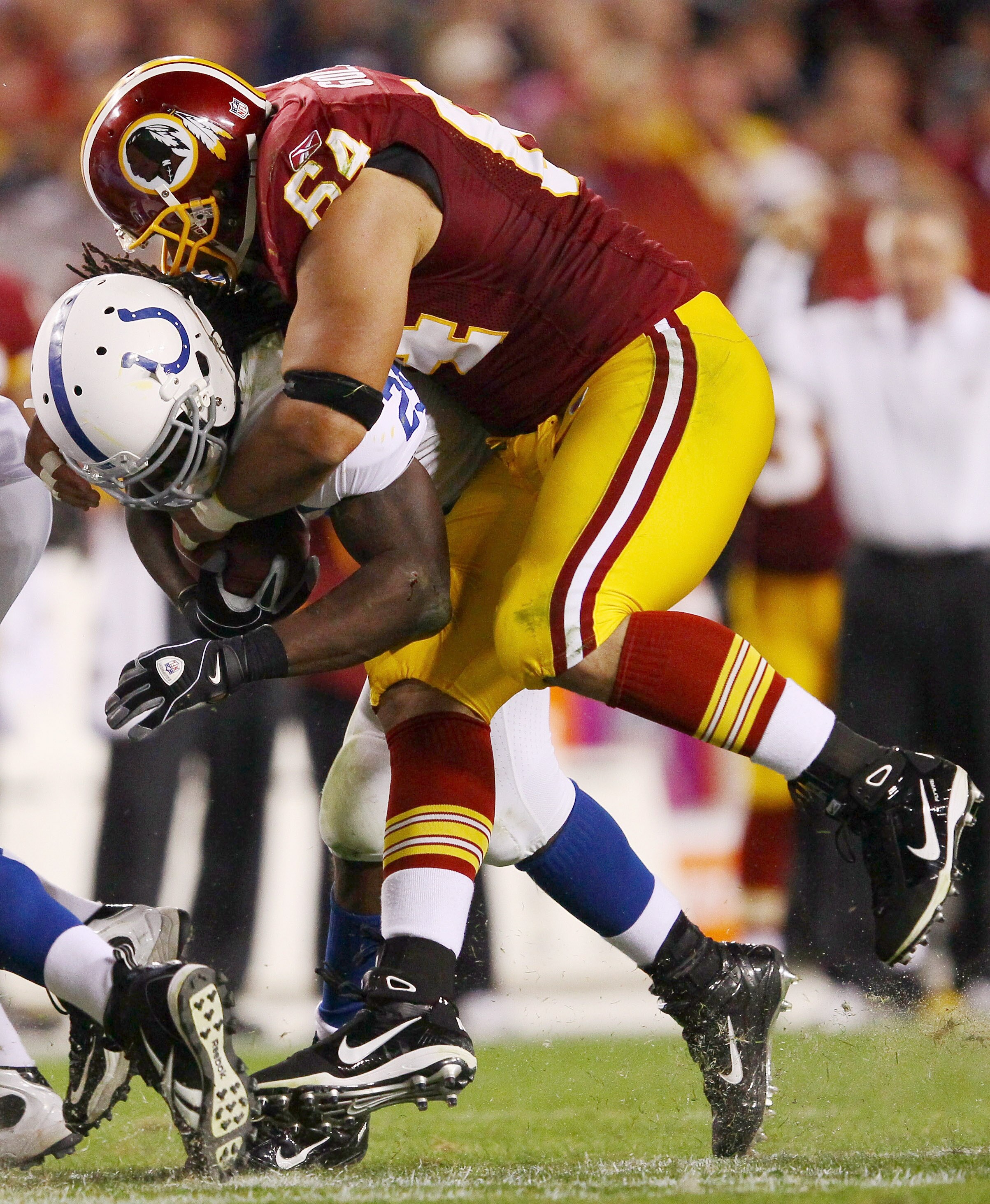 LANDOVER, MD - OCTOBER 17:  Running back Joseph Addai #29 of the Indianapolis Colts is tackled by Kedric Golston #64 of the Washington Redskins at FedEx Field on October 17, 2010 in Landover, Maryland. The Colts won the game 27-24.  (Photo by Win McNamee/