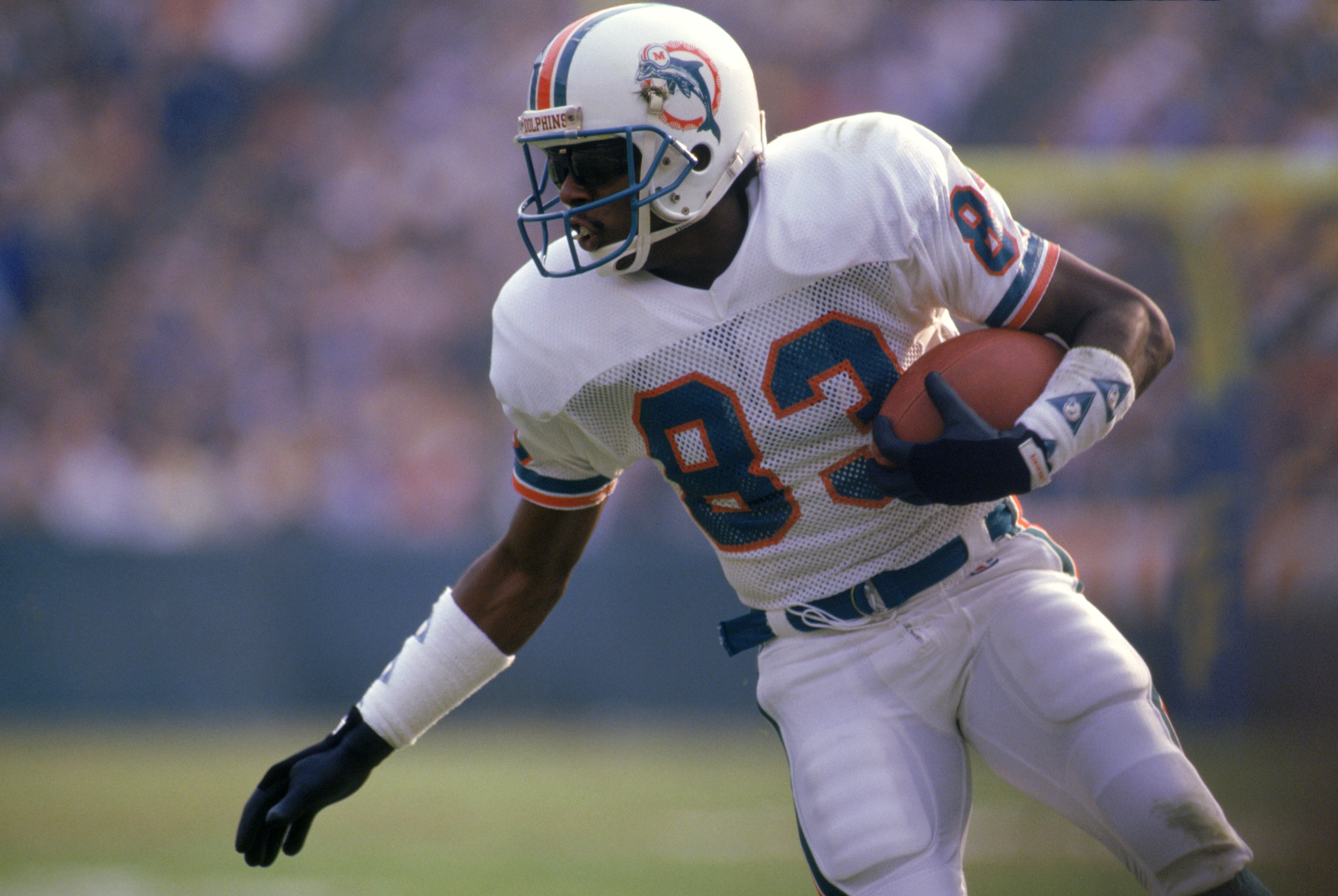 ANAHEIM, CA - DECEMBER 14:  Wide receiver Mark Clayton #83 of the Miami Dolphins runs with the ball during a game against the Los Angeles Rams at Anaheim Stadium on December 14, 1986 in Anaheim, California.   The Dolphins won 37-31 in overtime.  (Photo by
