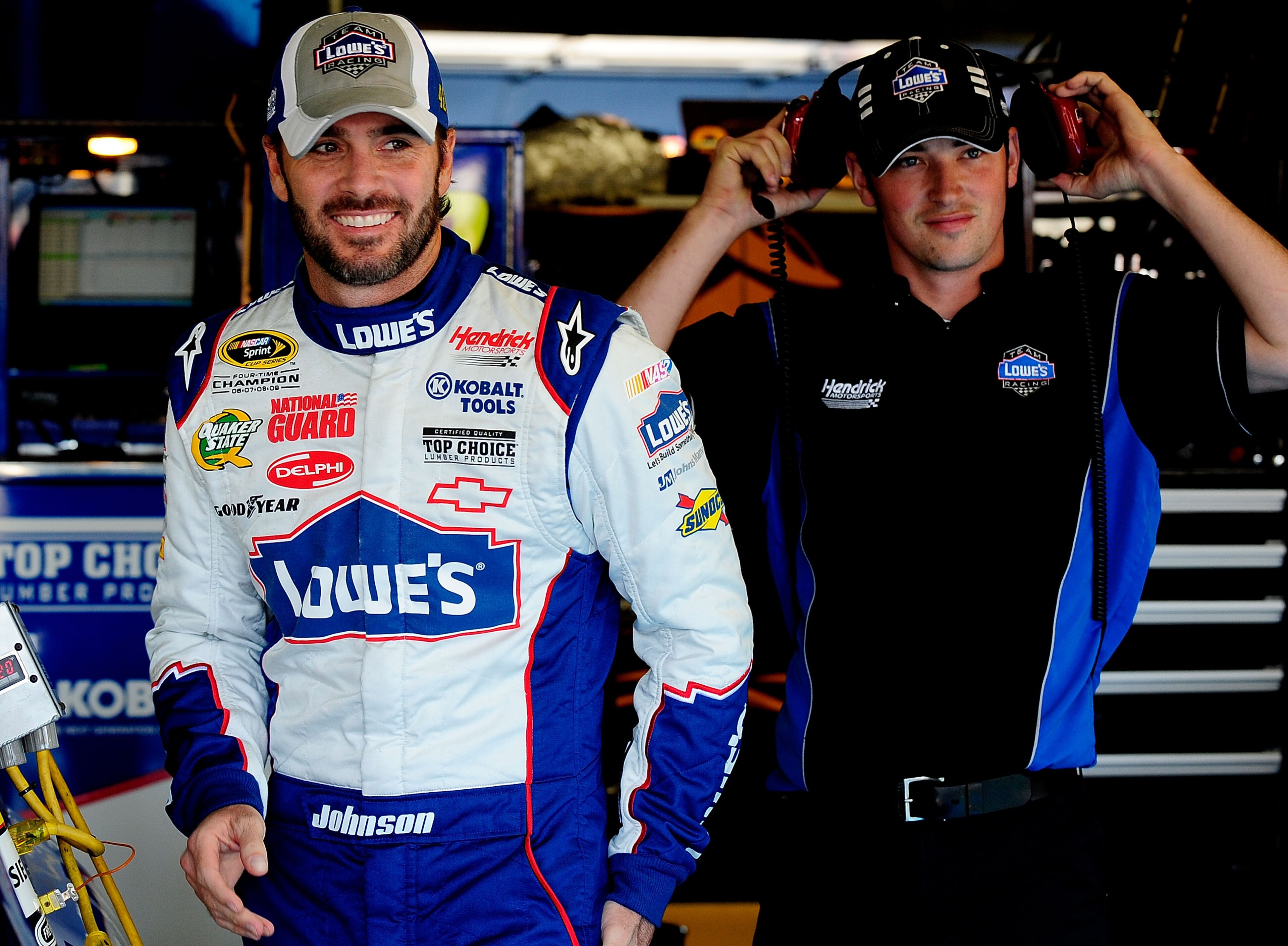 CONCORD, NC - OCTOBER 15:  Jimmie Johnson (L), driver of the #48 Lowe's Chevrolet, walks to his car prior in the garage prior to practice for the NASCAR Sprint Cup Series Bank of America 500 at Charlotte Motor Speedway on October 15, 2010 in Concord, Nort