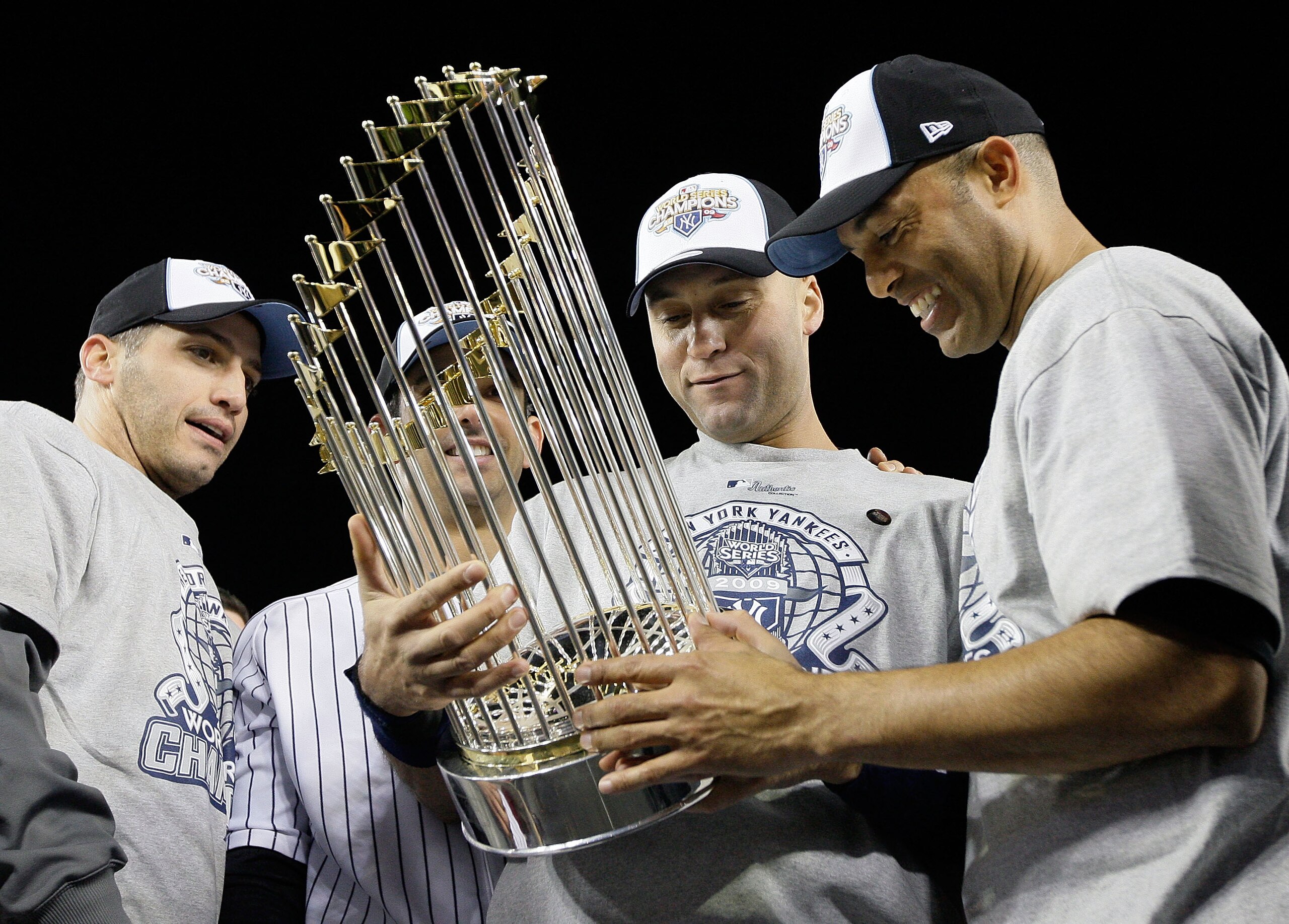 NEW YORK - NOVEMBER 04:  (L-R) Andy Pettitte #46, Jorge Posada #20, Derek Jeter #2 and Mariano Rivera #42 of the New York Yankees celebrate with the trophy after their 7-3 win against the Philadelphia Phillies in Game Six of the 2009 MLB World Series at Y