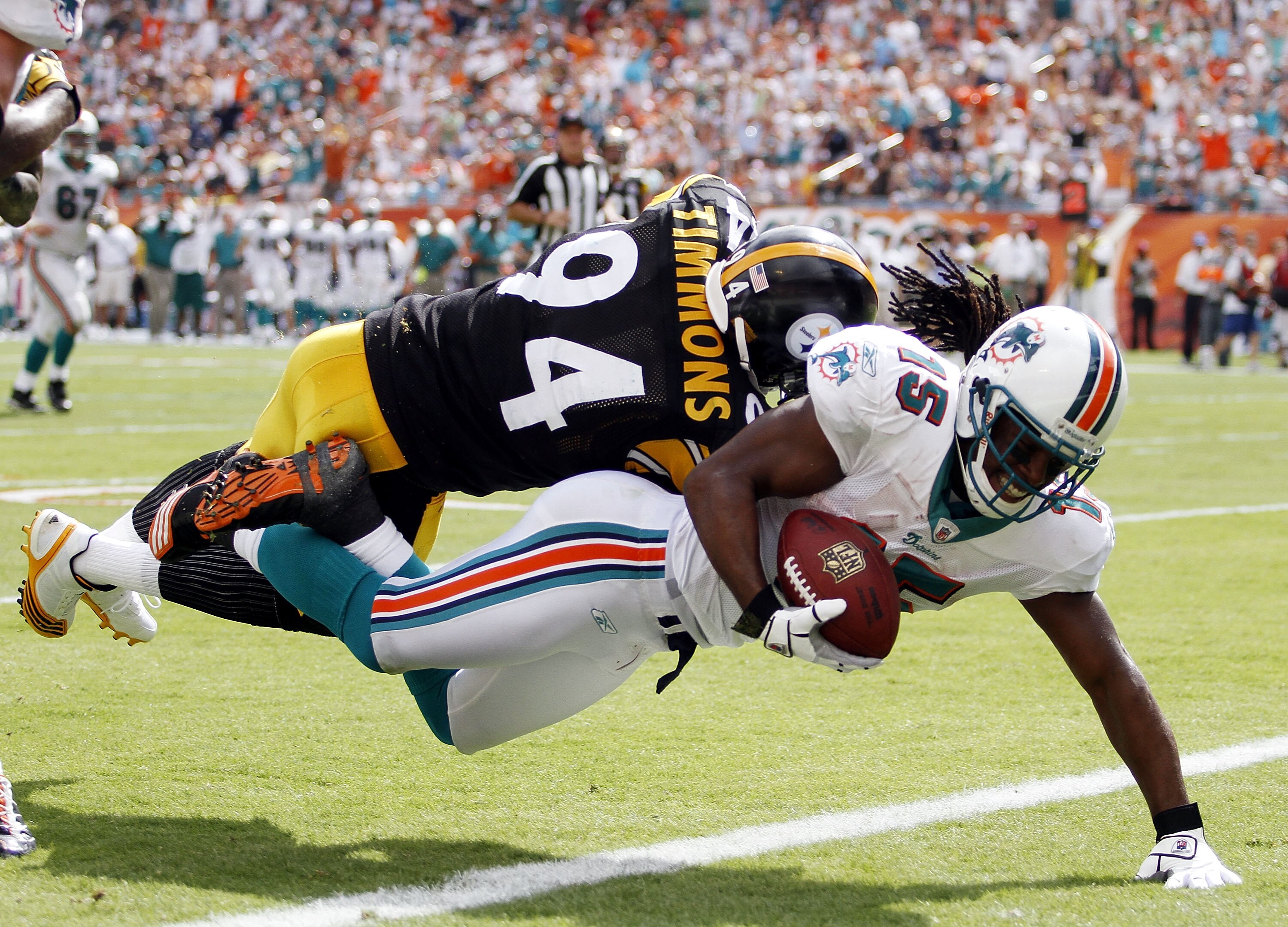 MIAMI - OCTOBER 24:  Receiver Davone Bess #15 scores a touchdown against linebacker Lawrence Timmons #94 of the Pittsburgh Steelers  at Sun Life Stadium on October 24, 2010 in Miami, Florida.  (Photo by Marc Serota/Getty Images)