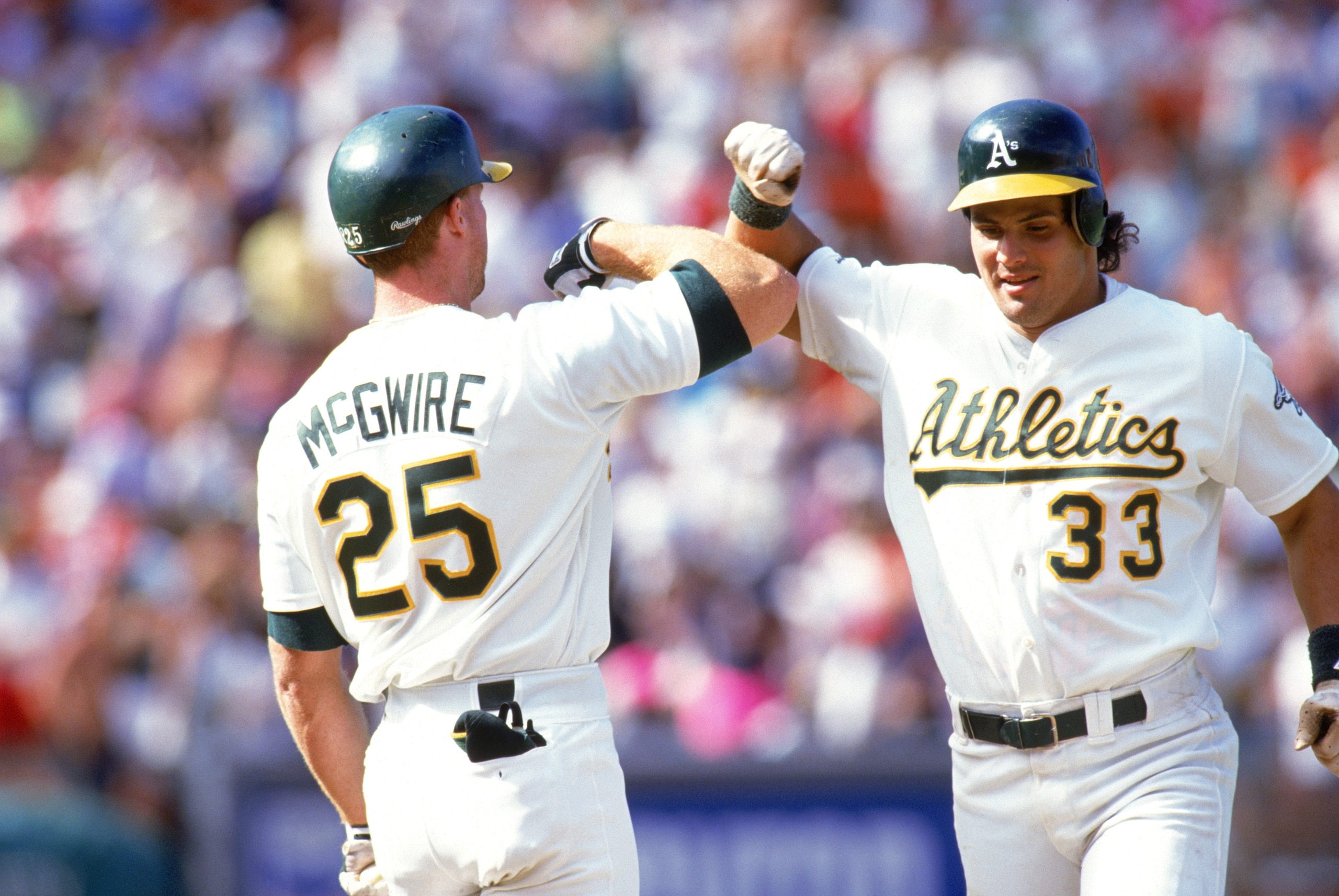 OAKLAND, CA - 1990:  Jose Canseco #33 and Mark McGwire #25 of the Oakland Athletics celebrate during a 1990 MLB season game at Oakland-Alameda County Coliseum in Oakland, California.  (Photo by Otto Greule Jr/Getty Images)