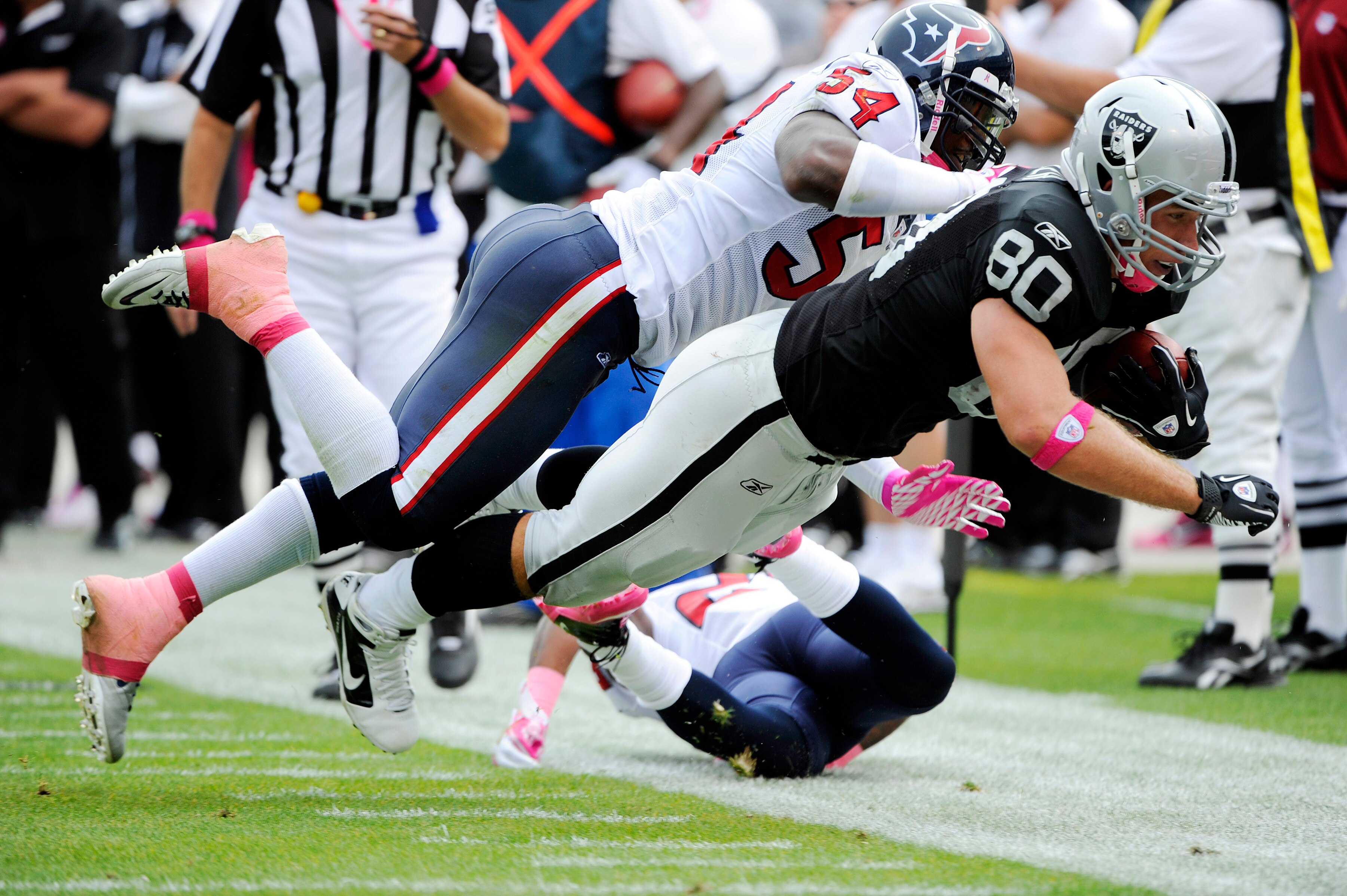 OAKLAND, CA - OCTOBER 3:  Tight end Zach Miller #80 of the Oakland Raiders is knocked out of bounds by linebacker Zac Diles #54 of the Houston Texans during an NFL football game October 3, 2010 at The Oakland-Alameda County Coliseum in Oakland, California