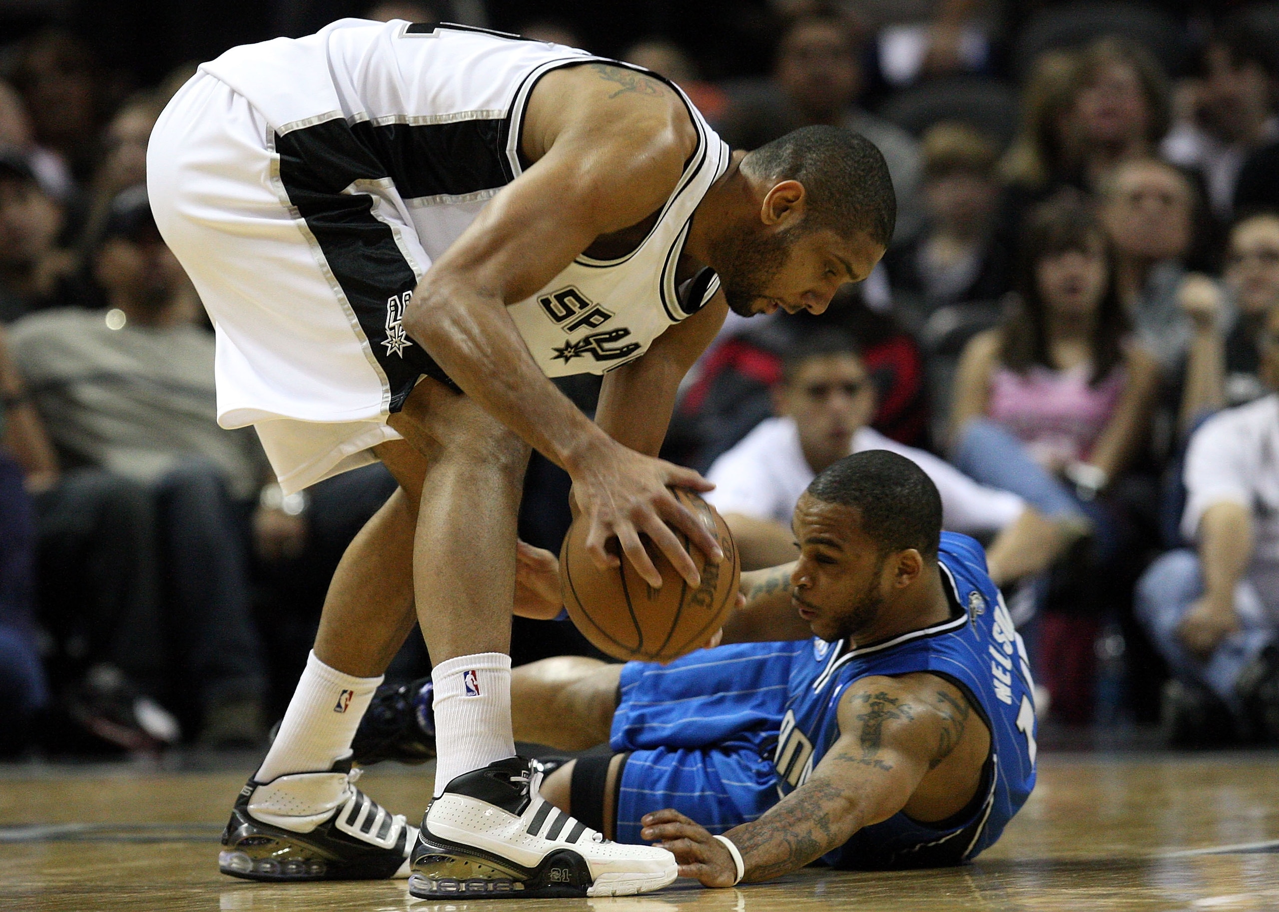 SAN ANTONIO - JANUARY 11:  Forward Tim Duncan #21 of the San Antonio Spurs holds onto the ball against Jameer Nelson #14 of the Orlando Magic on January 11, 2009 at AT&T Center in San Antonio, Texas.  NOTE TO USER: User expressly acknowledges and agrees t