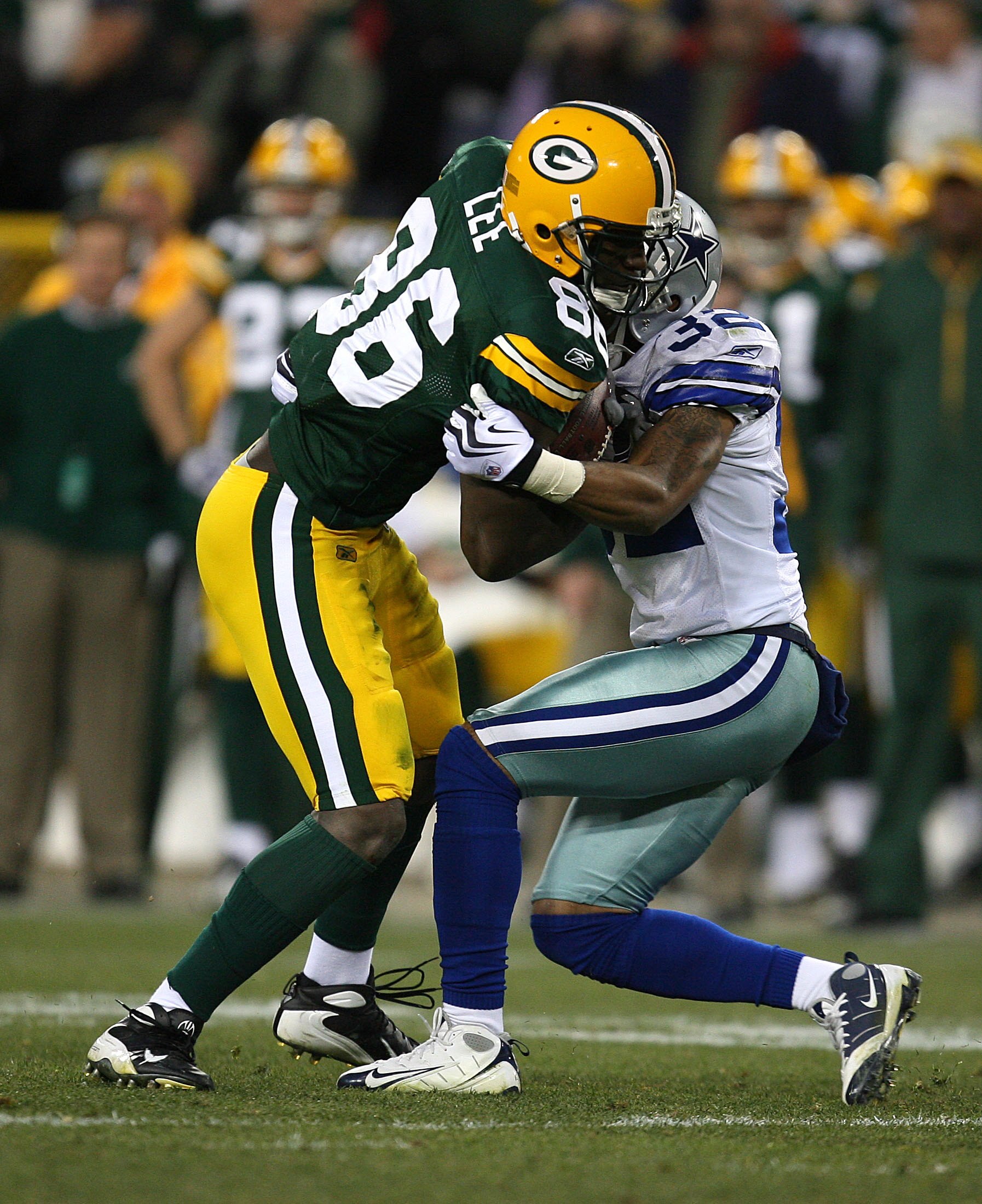 GREEN BAY, WI - NOVEMBER 15: Donlad Lee #86 of the Green Bay Packers is tackled by Orlando Scandrick #32 of the Dallas Cowboys at Lambeau Field on November 15, 2009 in Green Bay, Wisconsin. The Packers defeated the Cowboys 17-7. (Photo by Jonathan Daniel/