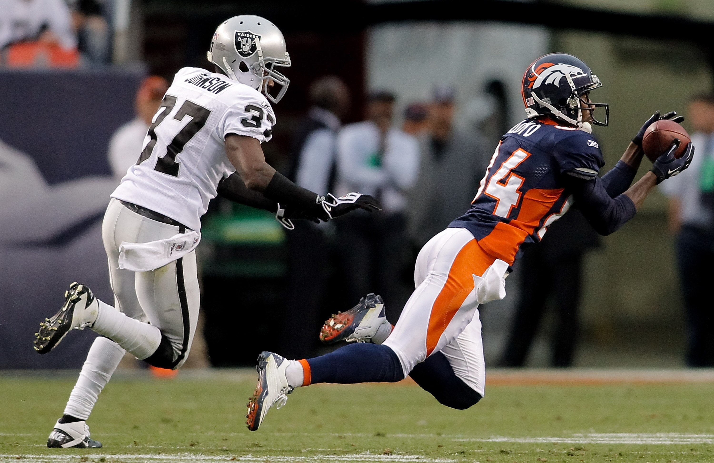 DENVER - OCTOBER 24: Wide receiver Brandon Lloyd #84 of the Denver Broncos makes a diving reception against cornerback Chris Johnson #37 of the Oakland Raiders in the fourth quarter at INVESCO Field at Mile High on October 24, 2010 in Denver, Colorado. T DENVER - OCTOBER 24: Wide receiver Brandon Lloyd #84 of the Denver Broncos makes a diving reception against cornerback Chris Johnson #37 of the Oakland Raiders in the fourth quarter at INVESCO Field at Mile High on October 24, 2010 in Denver, Colorado. T