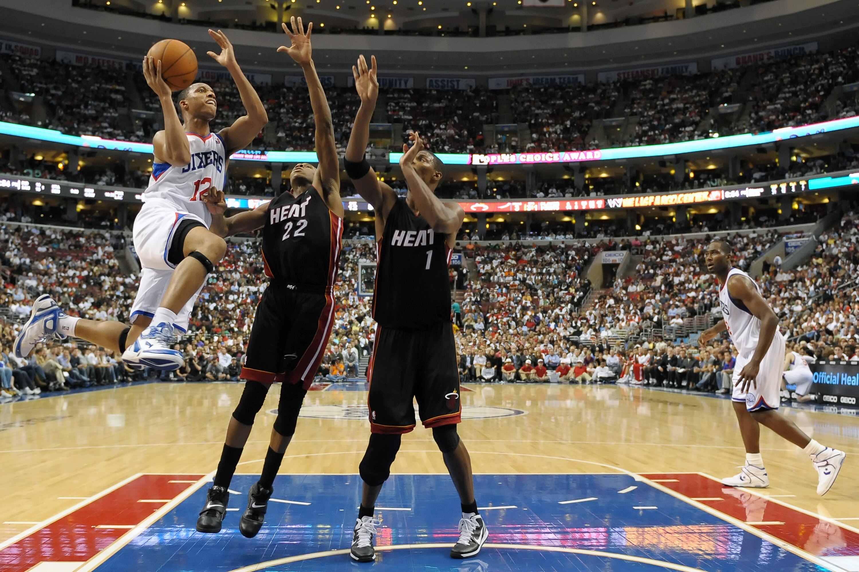 PHILADELPHIA - OCTOBER 27:  Evan Turner #12 of the Philadelphia 76ers goes up for a shot past James Jones #22 and Chris Bosh #1 of the Miami Heat at the Wells Fargo Center on October 27, 2010 in Philadelphia, Pennsylvania. NOTE TO USER: User expressly ack