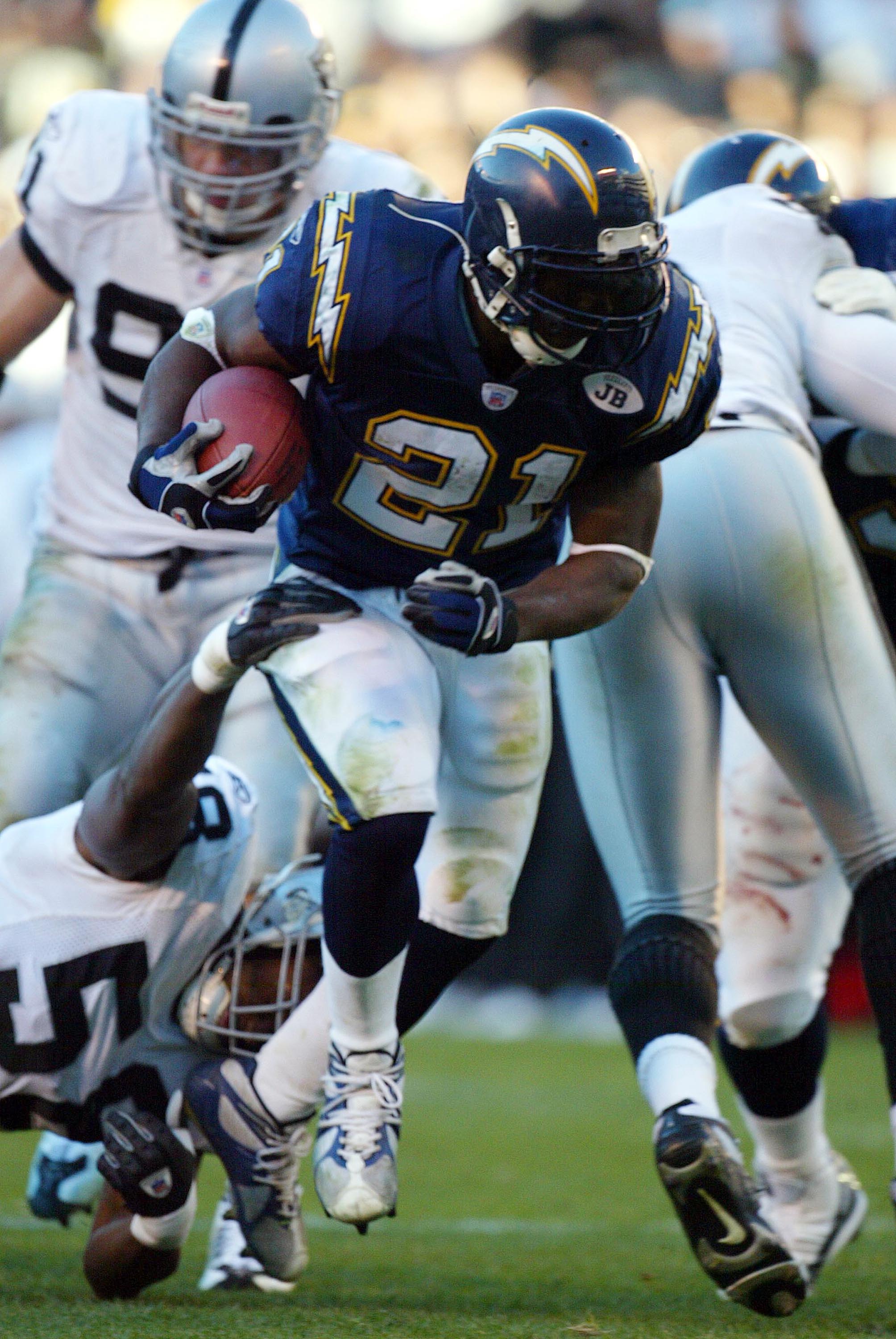 SAN DIEGO - DECEMBER 28:  Runningback LaDainian Tomlinson #21 of the San Diego Chargers runs through the defense of the Oakland Raiders in the 2nd half  during their NFL  game on December 28, 2003 at Qualcomm Stadium in San Diego, California. Tomlinson be