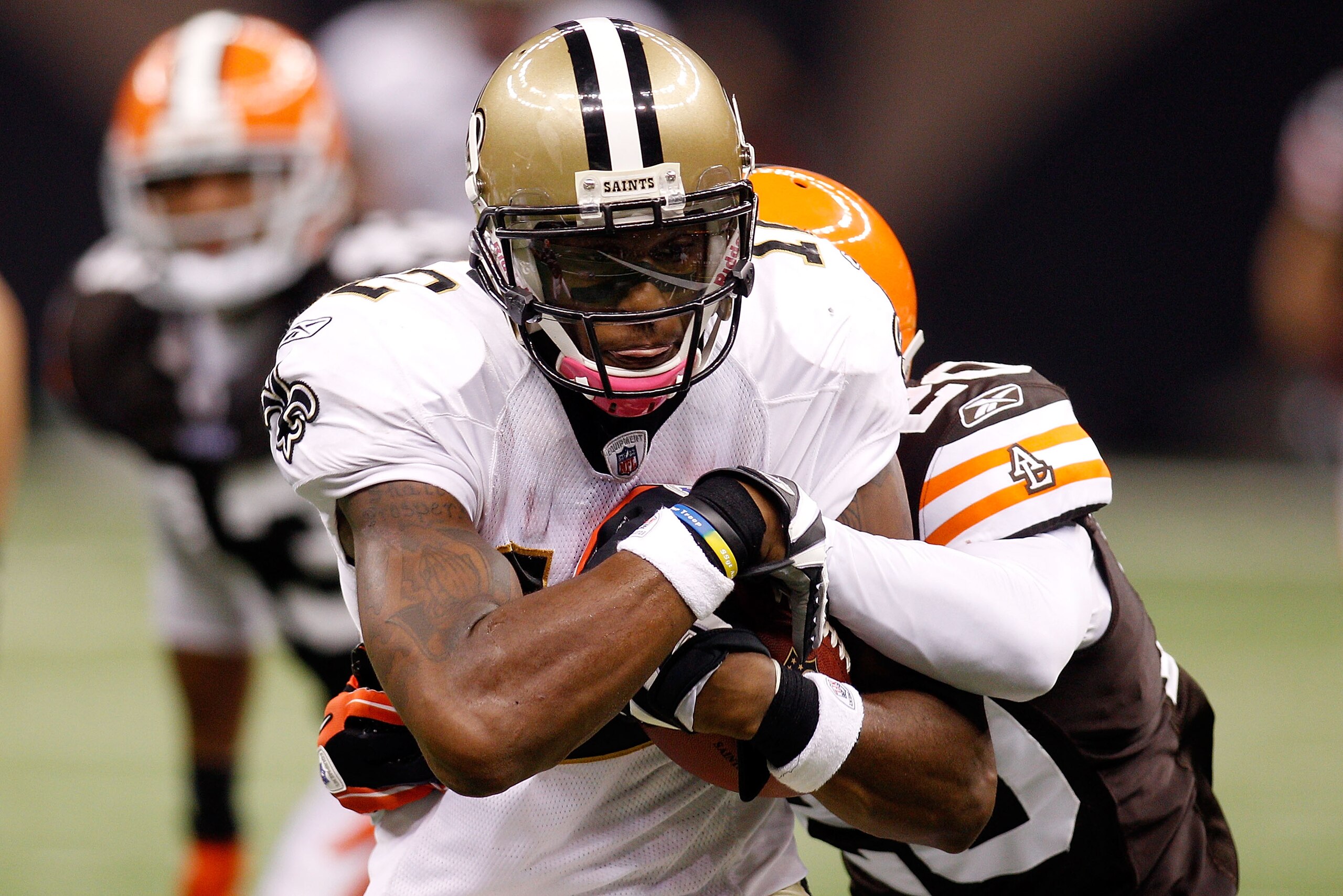 NEW ORLEANS - OCTOBER 24:  Marques Colston #12 of the New Orleans Saints is tackled by Mike Adams #20 of the Cleveland Browns at the Louisiana Superdome on October 24, 2010 in New Orleans, Louisiana.  The Browns defeated the Saints 30-17.  (Photo by Chris