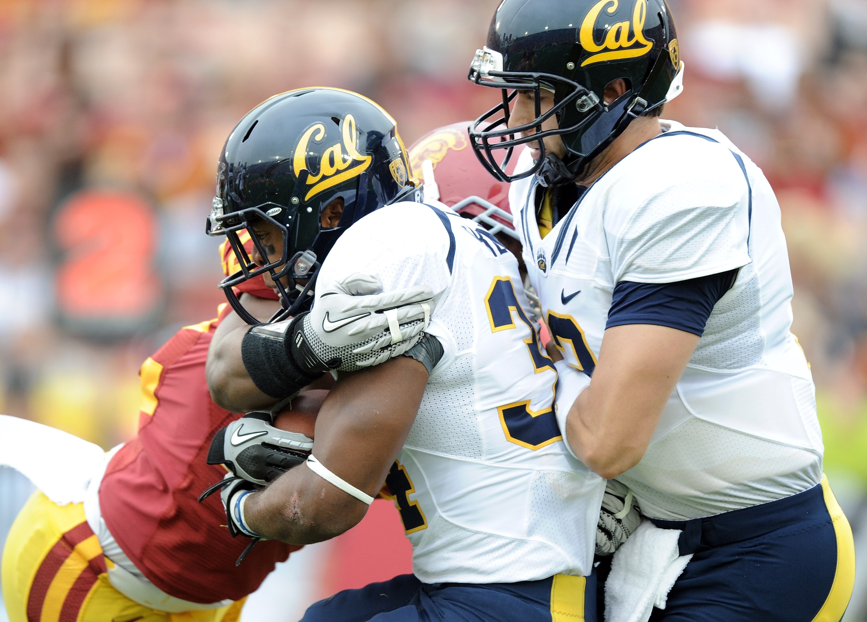LOS ANGELES, CA - OCTOBER 16:  Shane Vereen #34 of the California Golden Bears is knocked back into Kevin Riley #13 for a loss by Hunter Simmons #48 of the USC Trojans during the first quarter at Los Angeles Memorial Coliseum on October 16, 2010 in Los An