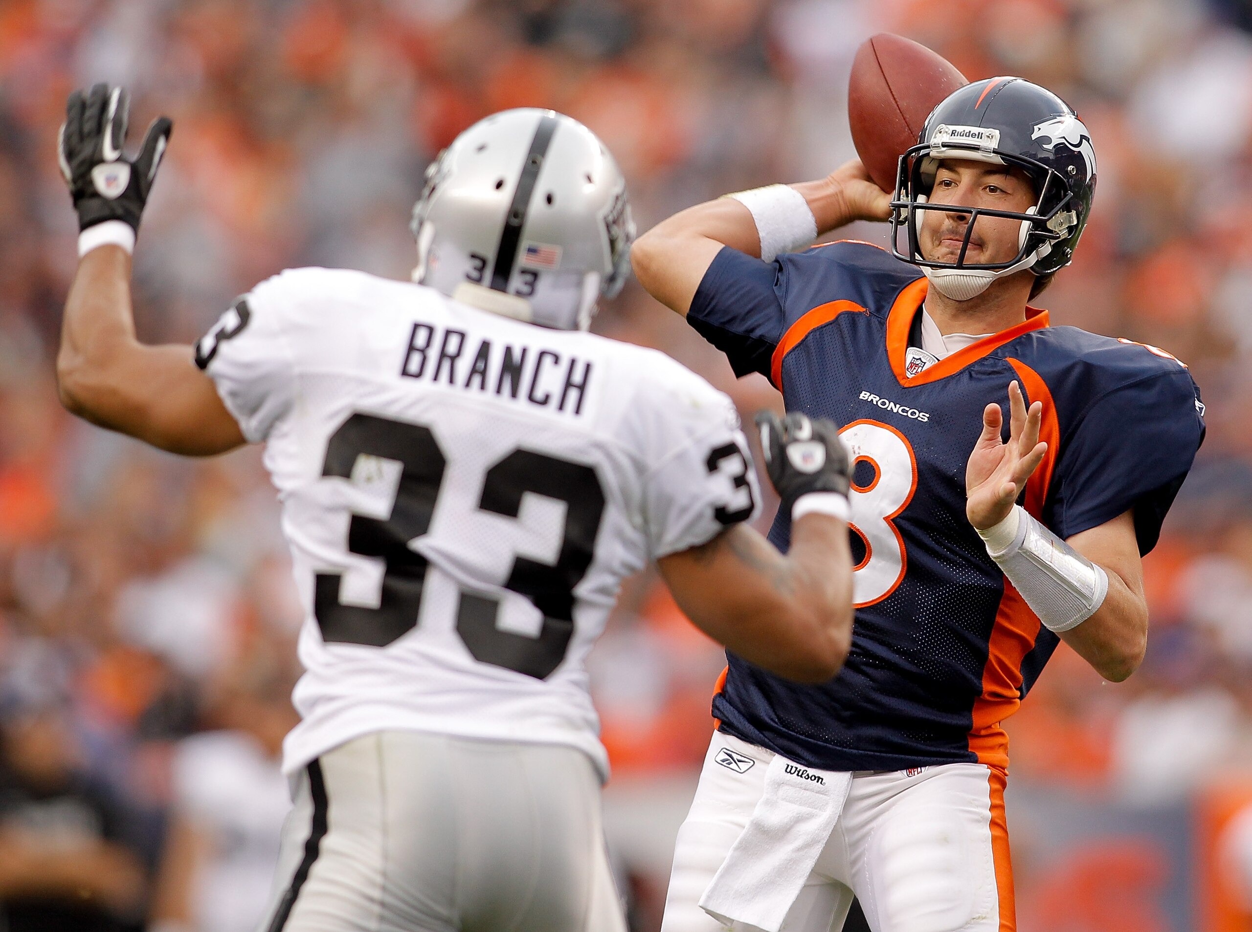 DENVER - OCTOBER 24:  Quarterback Kyle Orton #8 of the Denver Broncos makes a pass in front of safety Tyvon Branch #33 of the Oakland Raiders in the second quarter at INVESCO Field at Mile High on October 24, 2010 in Denver, Colorado. (Photo by Justin Edm