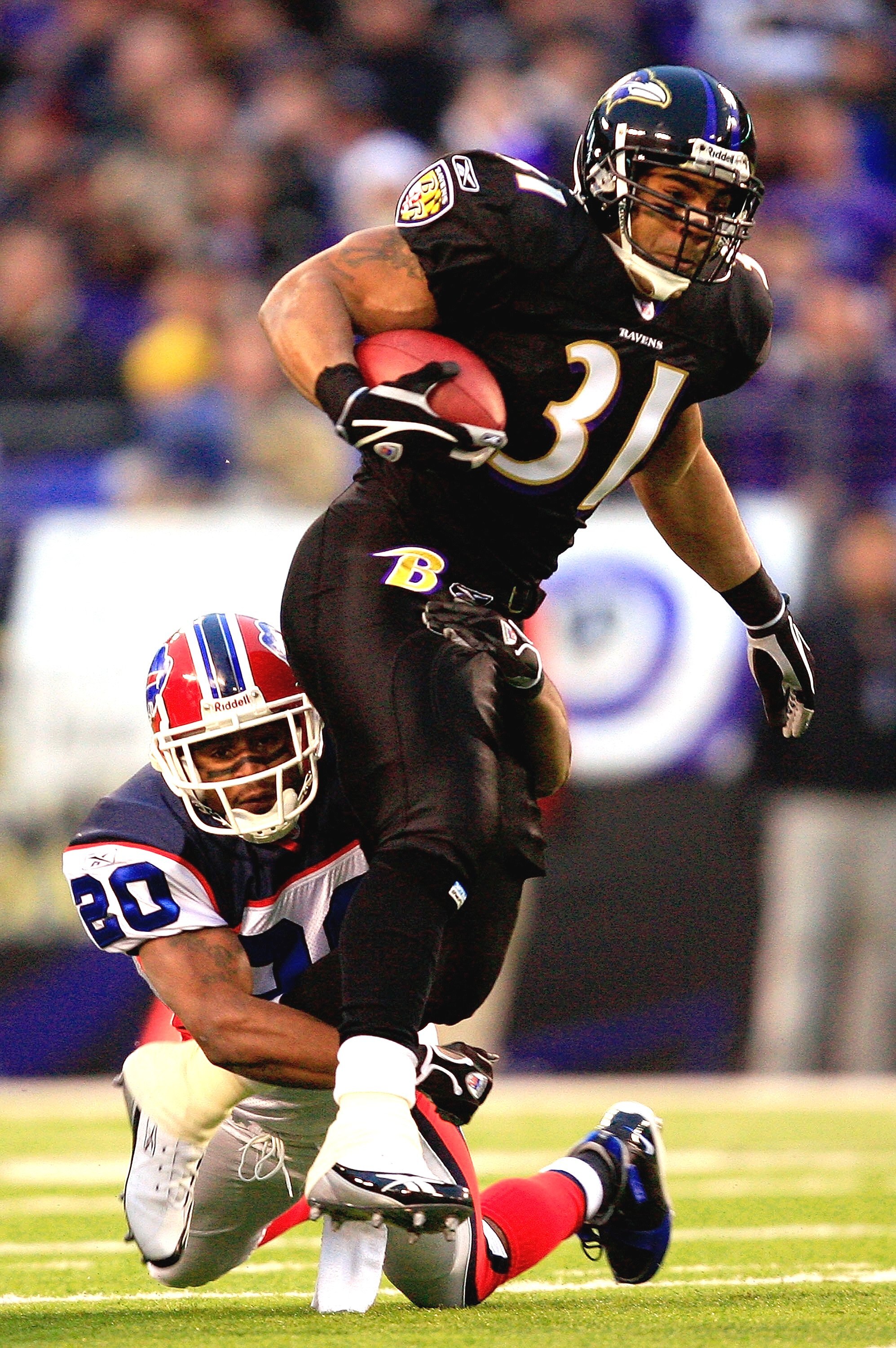 BALTIMORE - DECEMBER 31:  Jamal Lewis #31 of the Baltimore Ravens carries the ball as Donte Whitner #20 of the Buffalo Bills defends during the first half of the game on December 31, 2006 at M&T Bank Stadium in Baltimore, Maryland.  (Photo by Jamie Squire