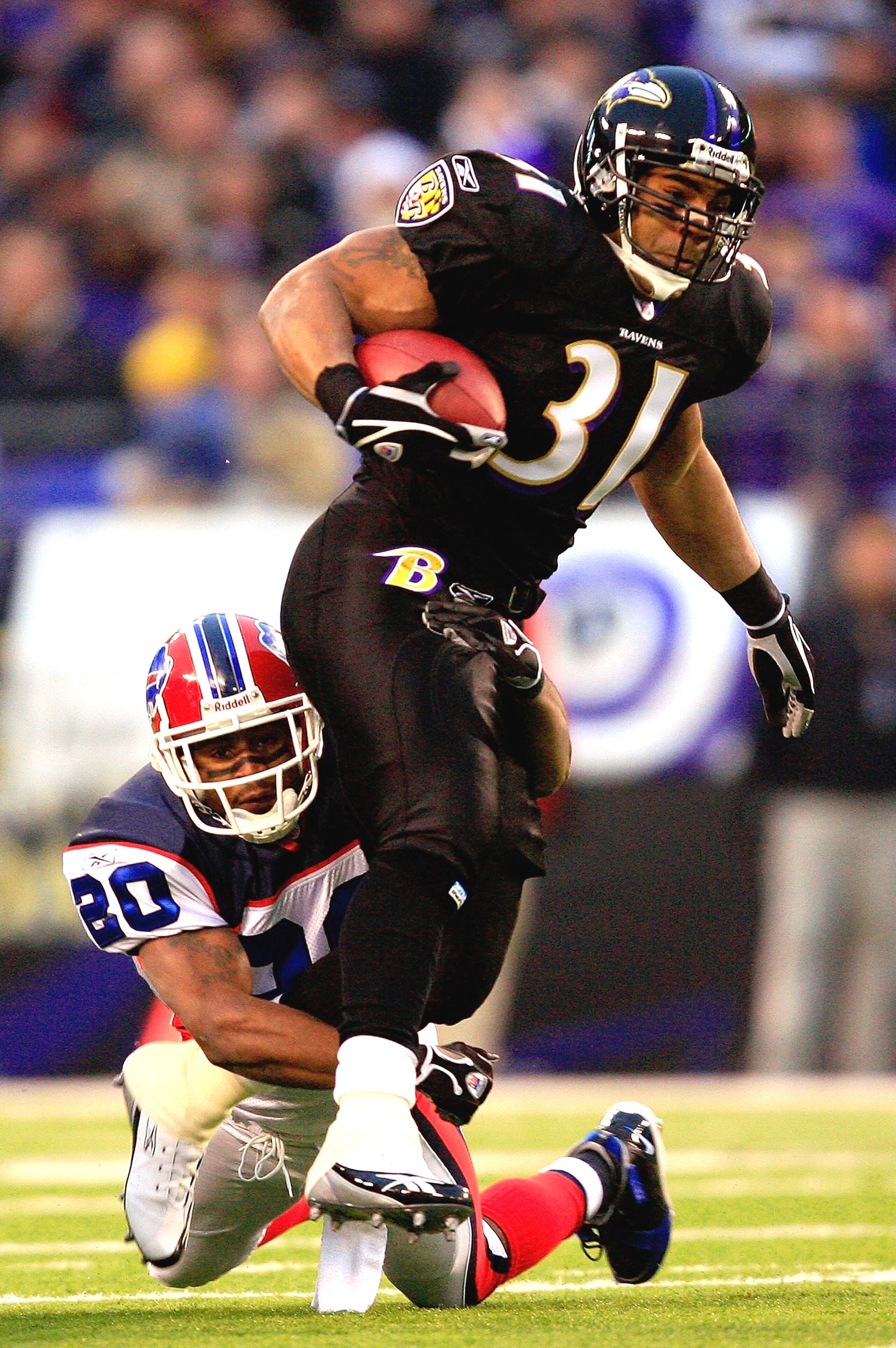 BALTIMORE - DECEMBER 31:  Jamal Lewis #31 of the Baltimore Ravens carries the ball as Donte Whitner #20 of the Buffalo Bills defends during the first half of the game on December 31, 2006 at M&T Bank Stadium in Baltimore, Maryland.  (Photo by Jamie Squire