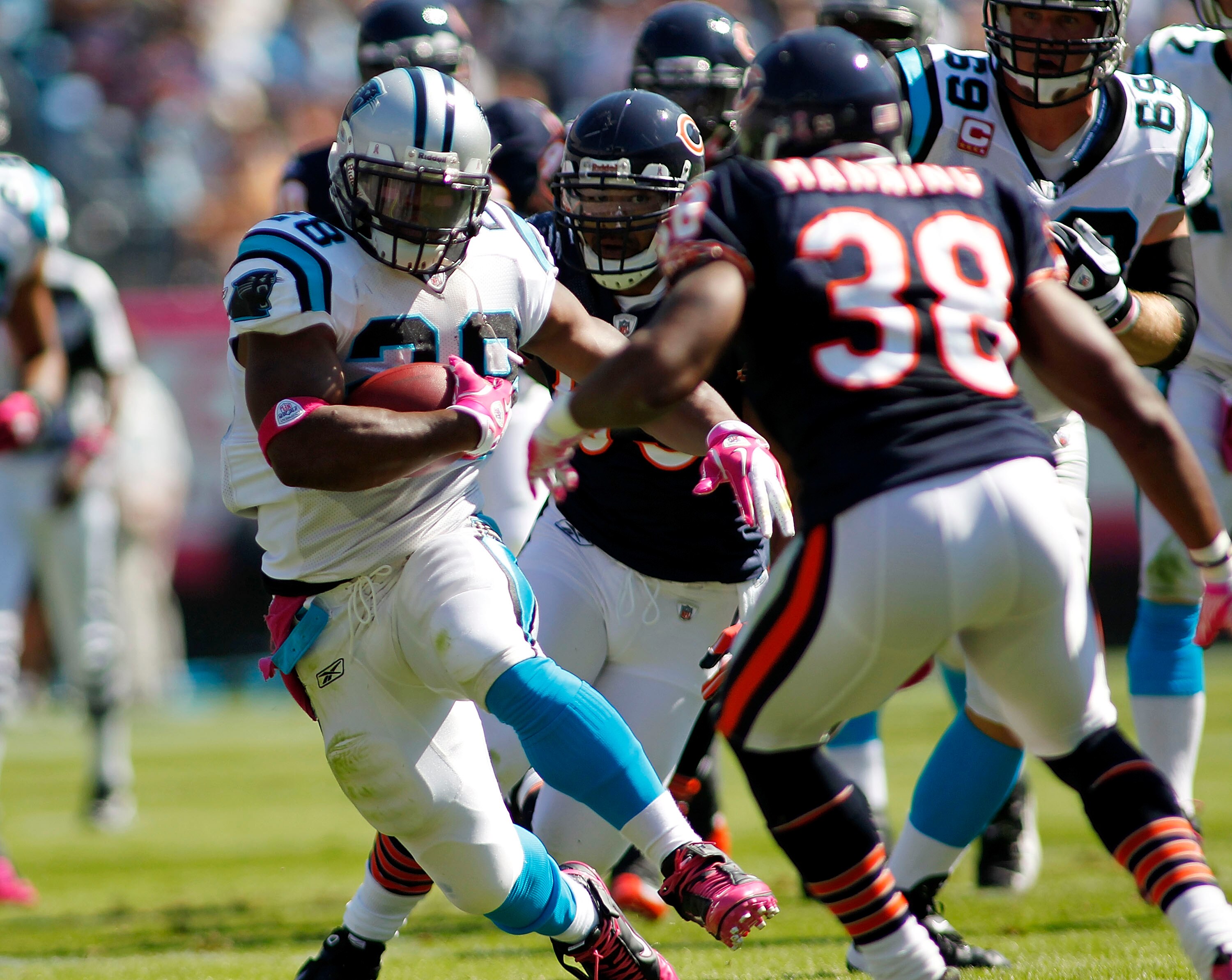 CHARLOTTE, NC - OCTOBER 10: Running back Jonathan Stewart #28 of the Carolina Panthers runs with the ball as defensive end Julius Peppers #90 and safety Danieal Manning #38 of the Chicago Bears defend at Bank of America Stadium on October 10, 2010 in Char