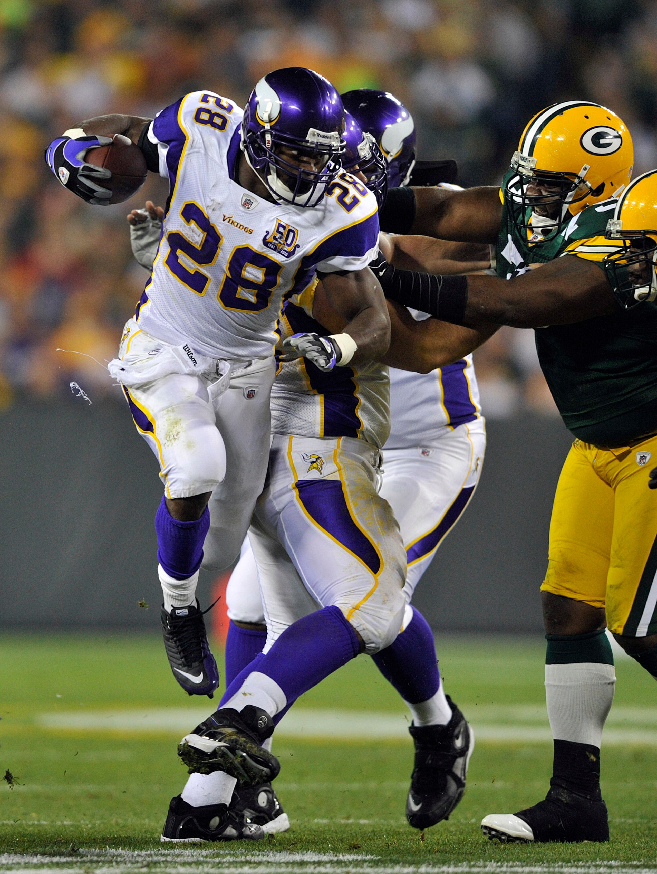 GREEN BAY, WI - OCTOBER 24:  Adrian Peterson #28 of the Minnesota Vikings leaps in the air for extra yardage against the Green Bay Packers at Lambeau Field on October 24, 2010 in Green Bay, Wisconsin. (Photo by Jim Prisching/Getty Images)