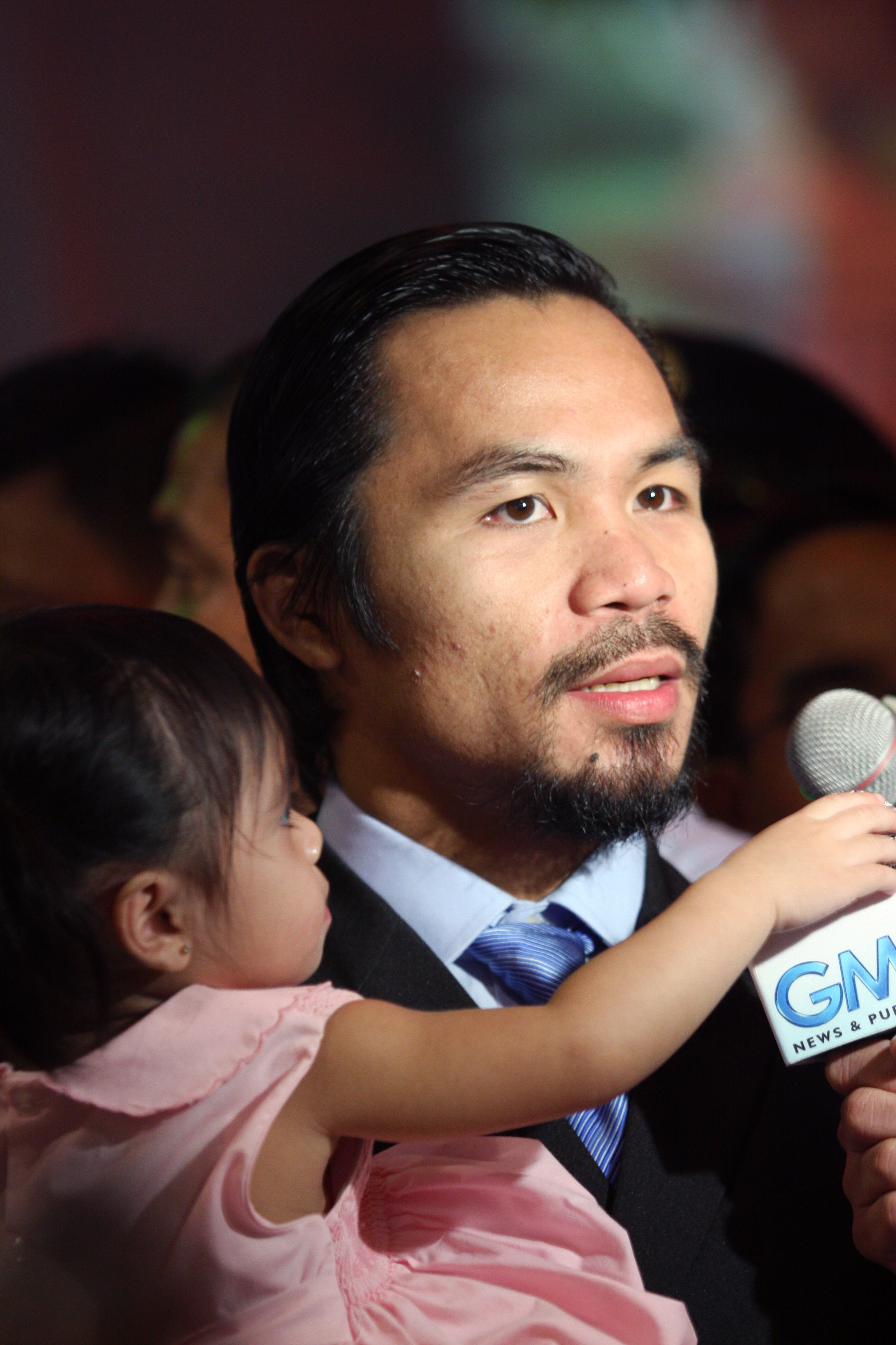 GENERAL SANTOS, PHILIPPINES - MAY 15:  World welterweight boxing champion Manny Pacquiao carries his daughter Queen  at the KCC Mall on May 15, 2010 in General Santos, Philippines. Pacquiao was there to celebrate his election on becoming a member of House