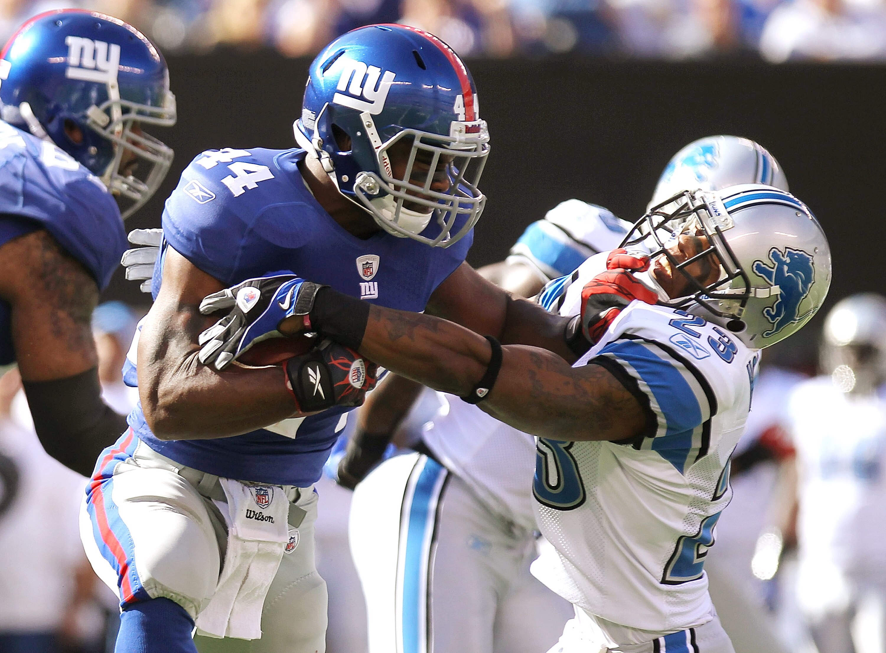 EAST RUTHERFORD, NJ - OCTOBER 17: Ahmad Bradshaw #44 of the New York Giants fends off Chris Houston #23 of the Detroit Lions at New Meadowlands Stadium on October 17, 2010 in East Rutherford, New Jersey.  (Photo by Nick Laham/Getty Images)