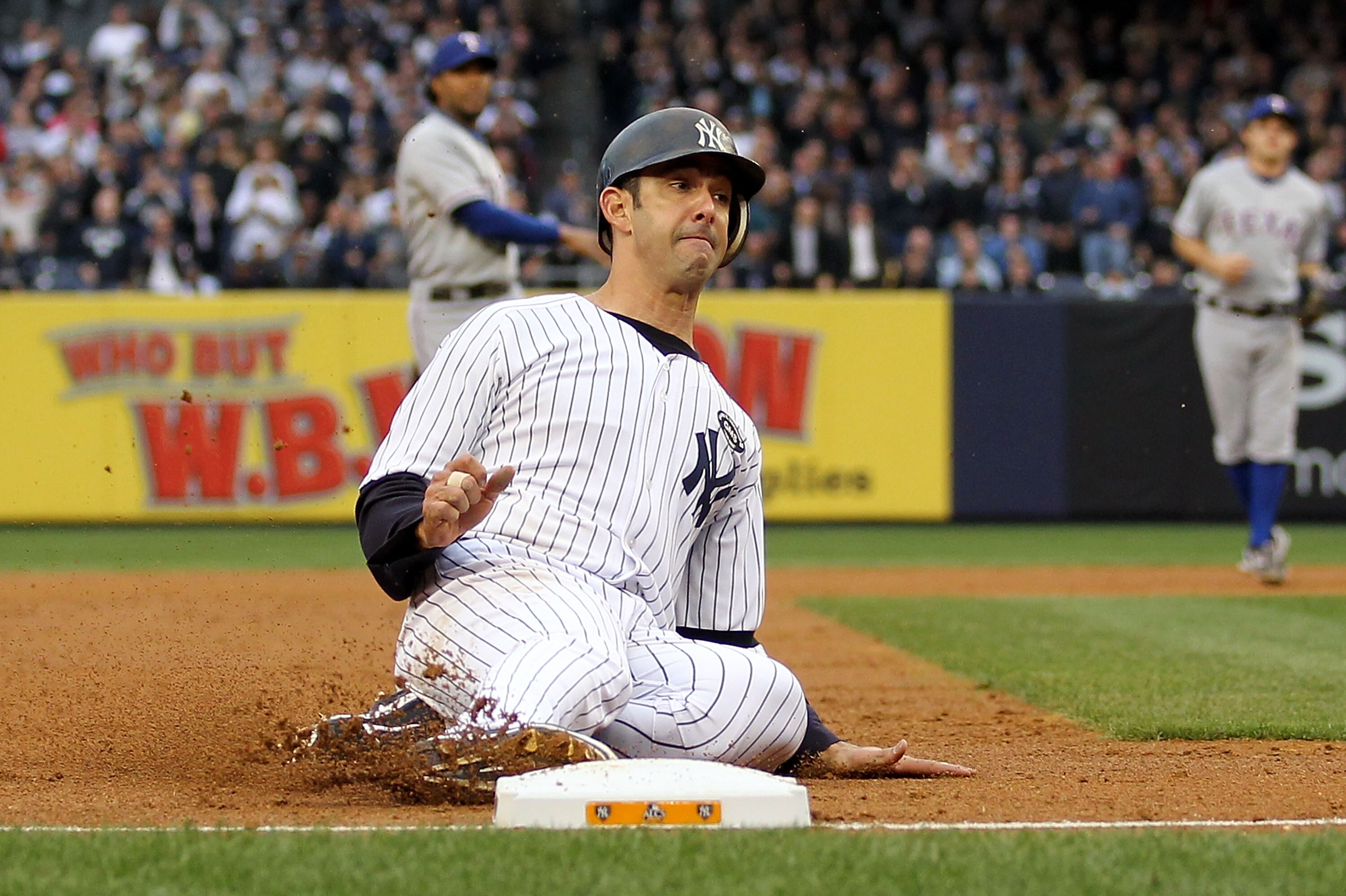 NEW YORK - OCTOBER 20:  Jorge Posada #20 of the New York Yankees is safe at third base on a throwing error by Jeff Francoeur #21 of the Texas Rangers on ball hit by Curtis Granderson #14 of the Yankees in the bottom of the seocnd inning of Game Five of th