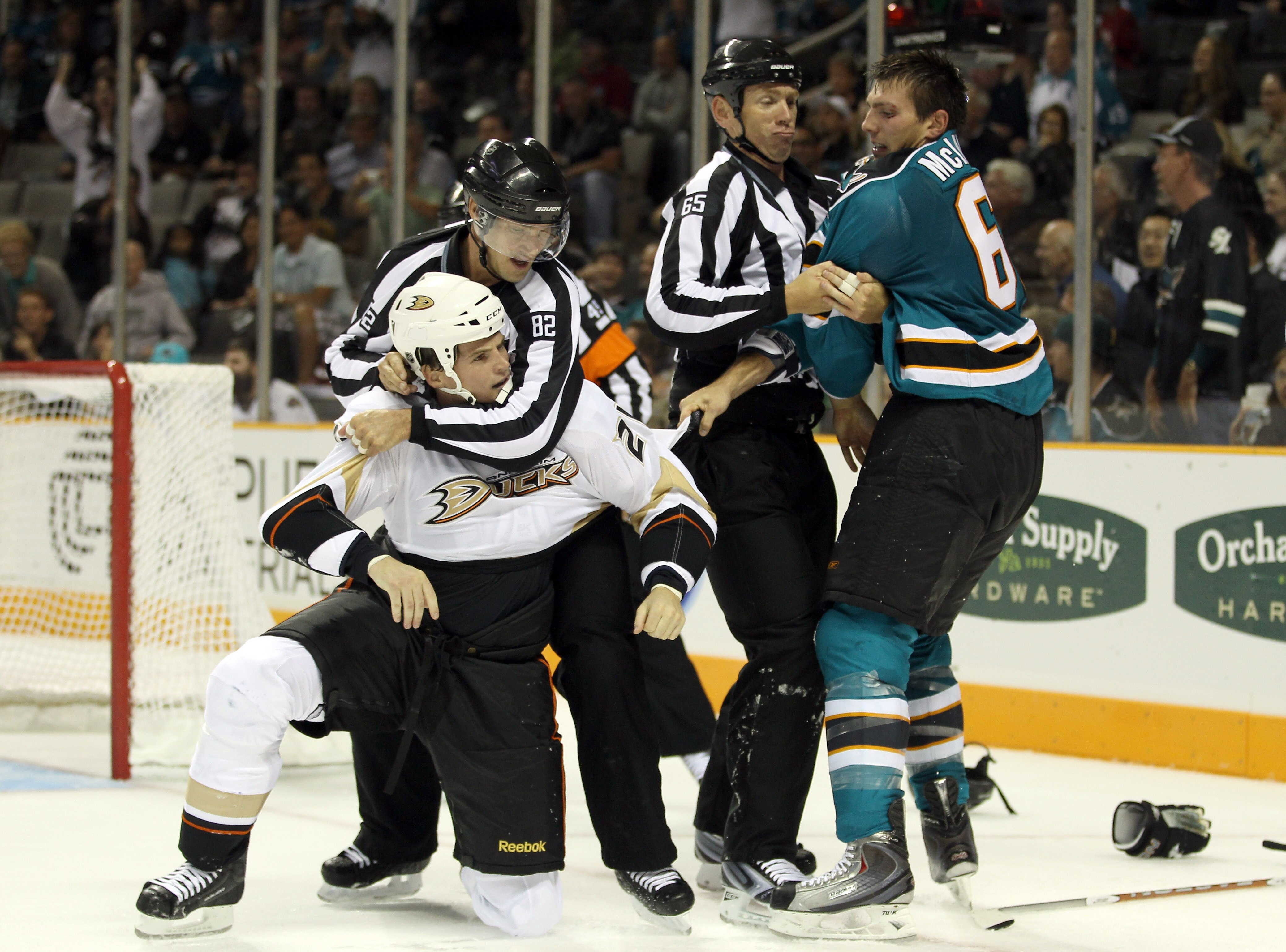 SAN JOSE, CA - SEPTEMBER 24:  Frazer McLaren #68 of the San Jose Sharks and Sheldon Brookbank #21 of the Anaheim Ducks are broken up by linesmen Pierre Racicot #65 and Ryan Galloway #82 during their preseason game at HP Pavilion on September 24, 2010 in S