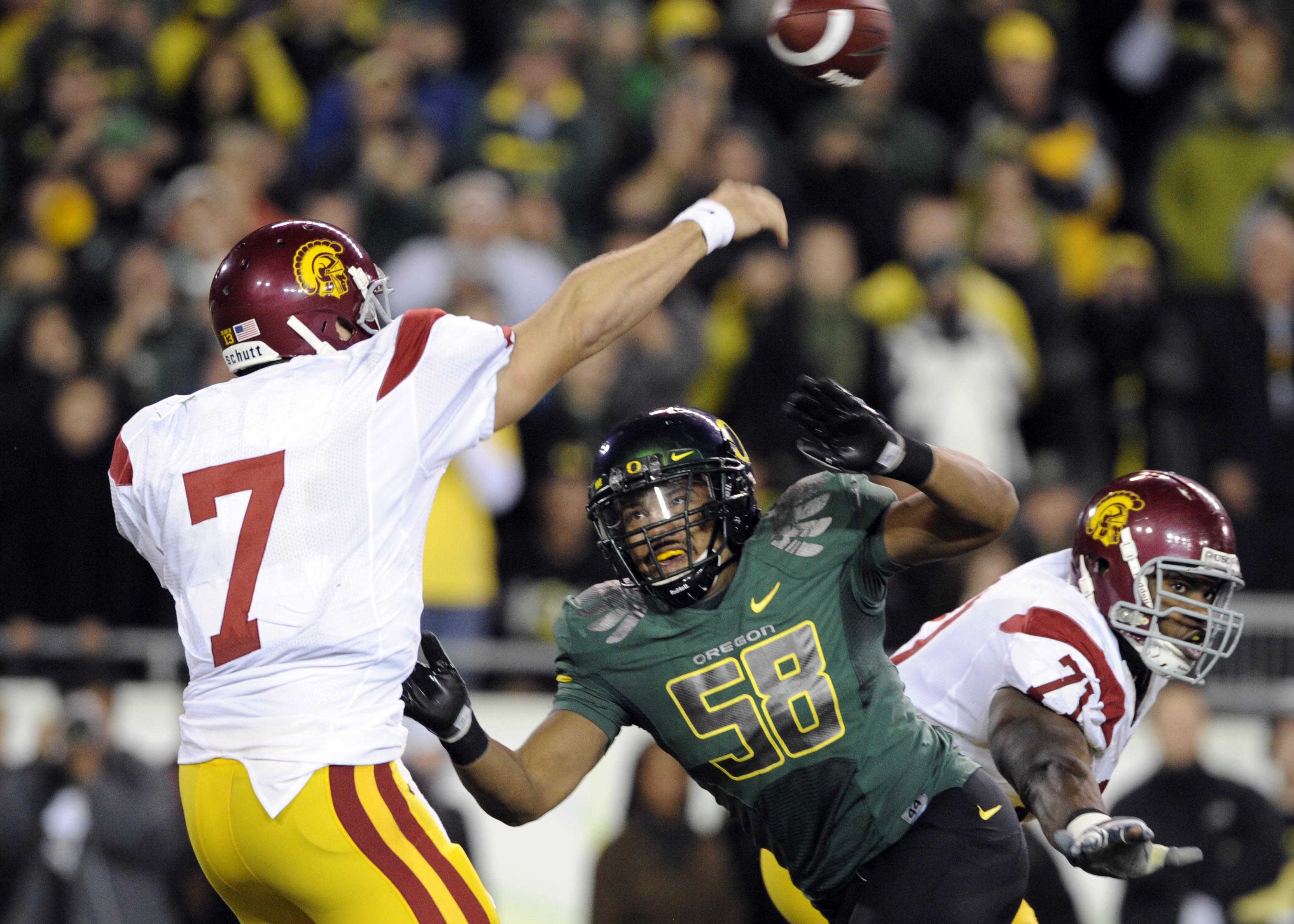EUGENE, OR - OCTOBER 31: Quarterback Matt Barkley #7 of the USC Trojans gets off a pass as defensive end Will Tukuafu #39 applies pressure in the fourth quarter of the game at Autzen Stadium on October 31, 2009 in Eugene, Oregon. The Ducks upset the Troja