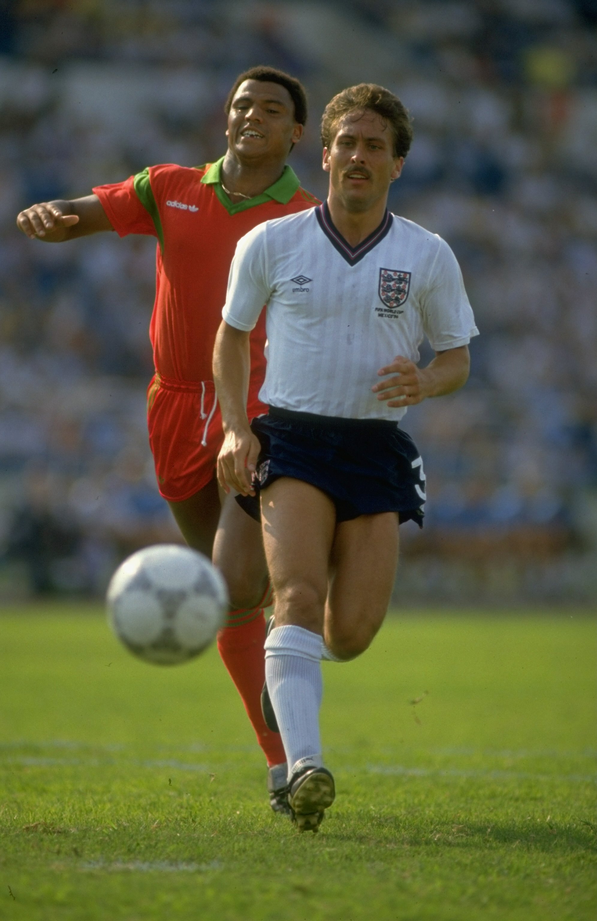 6 Jun 1986:  Kenny Sansom of England is chased by a Moroccan defender during the World Cup Group F match at the Estadio Tecnologico in Monterrey, Mexico. The match ended in a 0-0 draw. \ Mandatory Credit: Allsport UK /Allsport