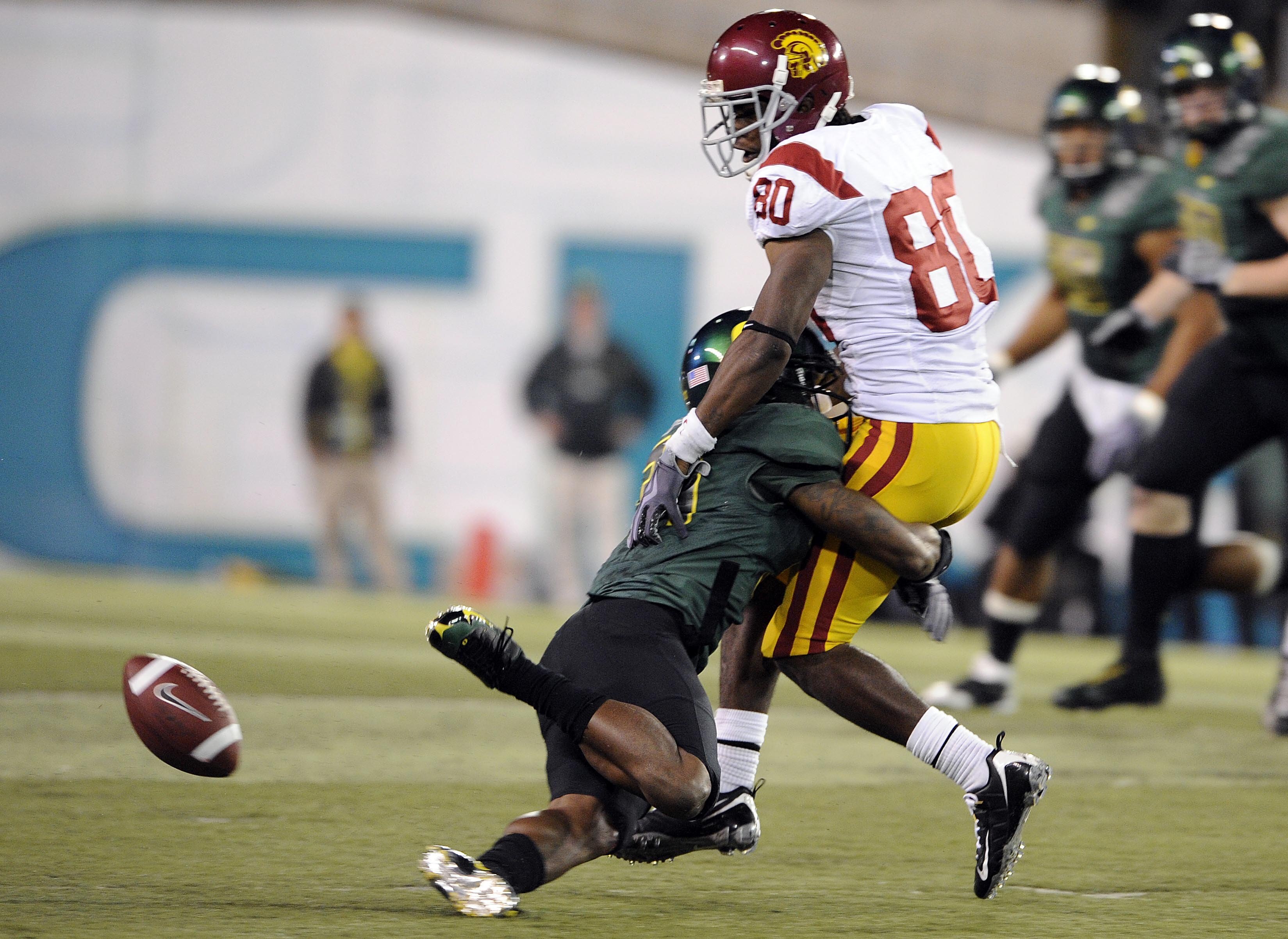 EUGENE, OR - OCTOBER 31: Wide receiver Brandon Carswell #80 of the USC Trojans is separated from the ball by cornerback Talmadge Jackson III #37 of the Oregon Ducks as he looks for some yardage in the first quarter of the game at Autzen Stadium on October