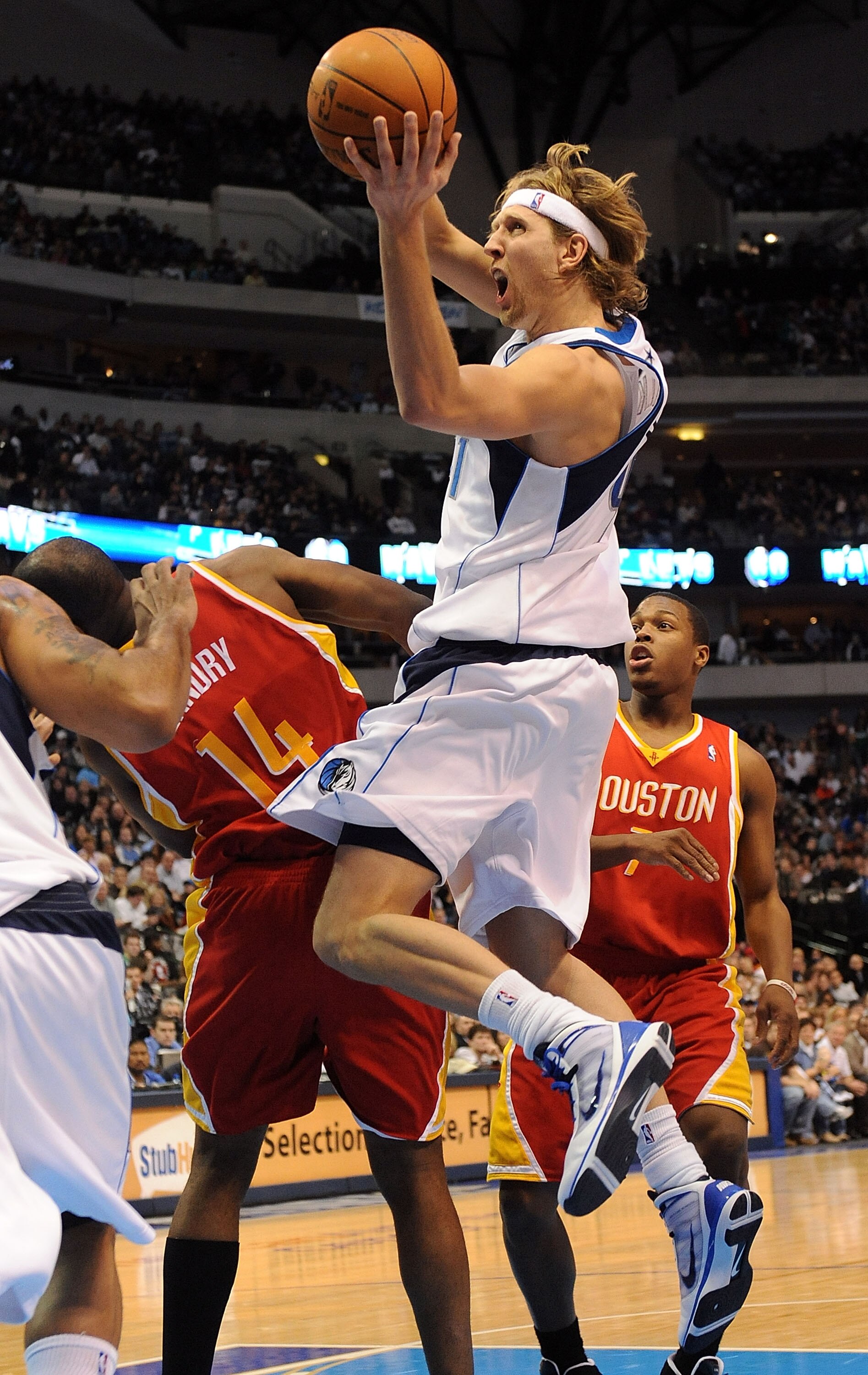 DALLAS - DECEMBER 18:  Forward Dirk Nowitzki #41 of the Dallas Mavericks takes a shot against Carl Landry #14 of the Houston Rockets on December 18, 2009 at American Airlines Center in Dallas, Texas.  NOTE TO USER: User expressly acknowledges and agrees t