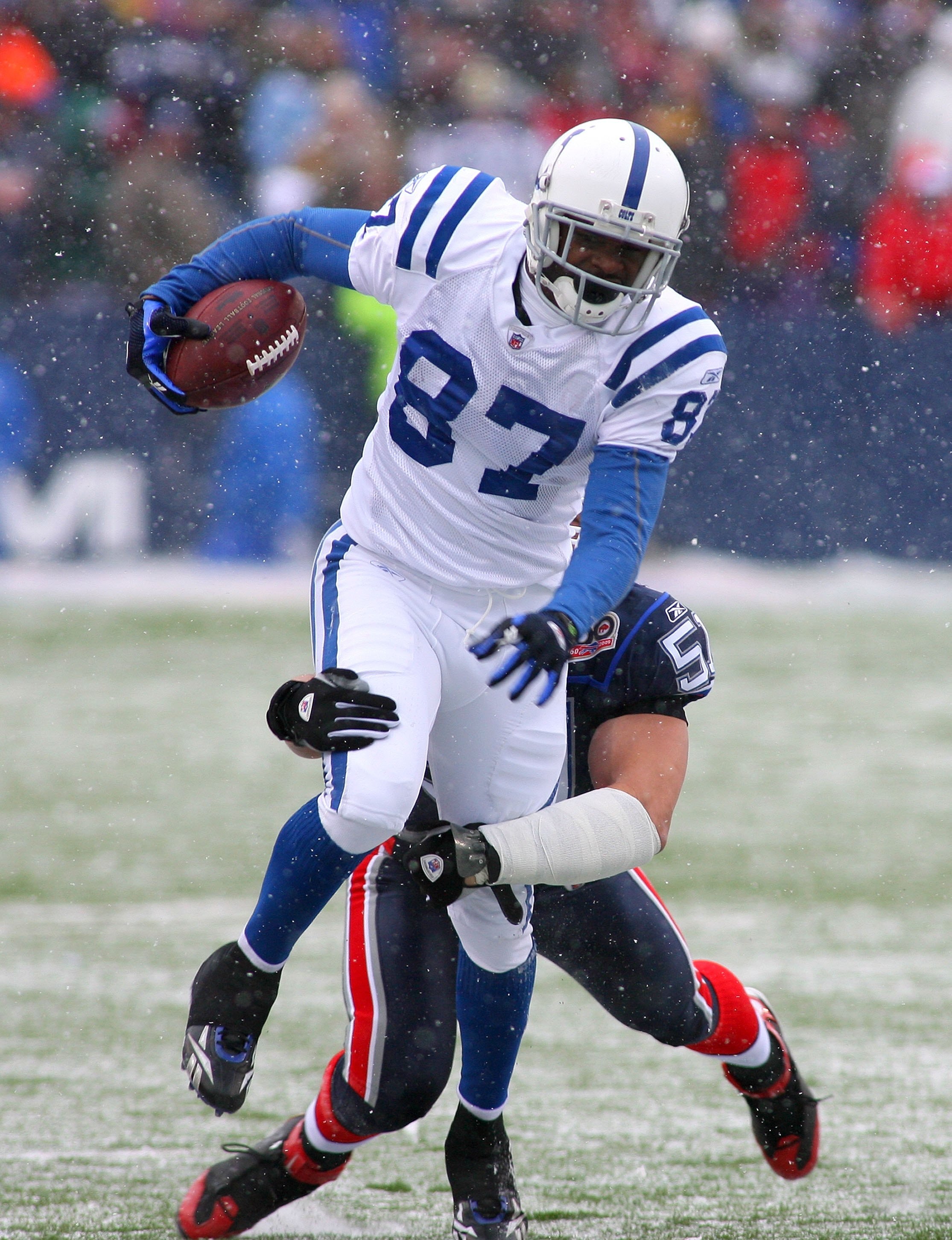 ORCHARD PARK, NY - JANUARY 3: Reggie Wayne #87 of the Indianapolis Colts runs after a catch as Paul Posluszny #51 of the Buffalo Bills comes in for the tackle at Ralph Wilson Stadium on January 3, 2010 in Orchard Park, New York. The Bills defeated the Col