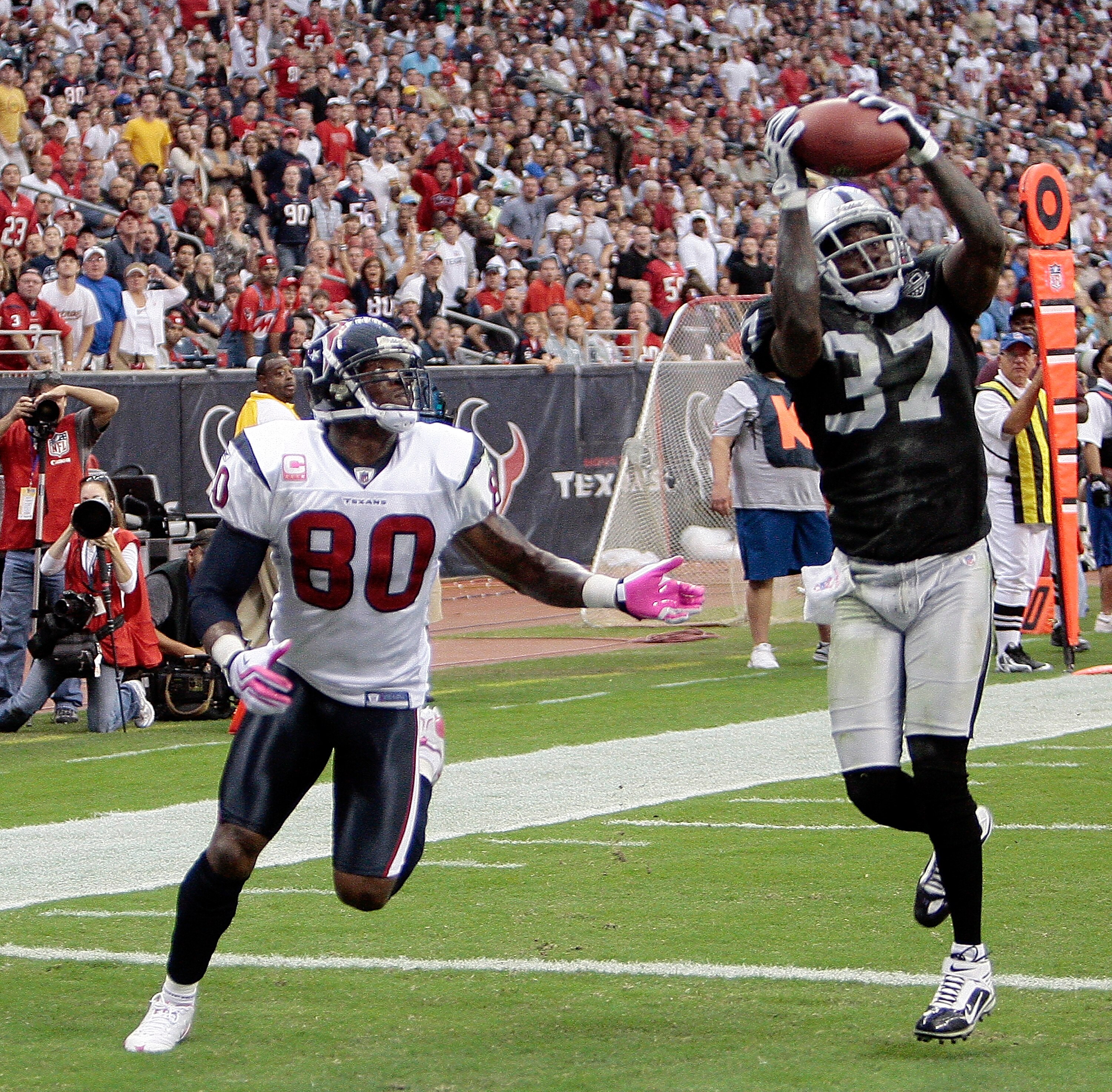 HOUSTON - OCTOBER 04:  Cornerback Chris Johnson #37 of the Oakland Raiders intercepts a pass intended for wide receiver Andre Johnson #80 of the Houston Texans in the first half at Reliant Stadium on October 4, 2009 in Houston, Texas.  (Photo by Bob Levey