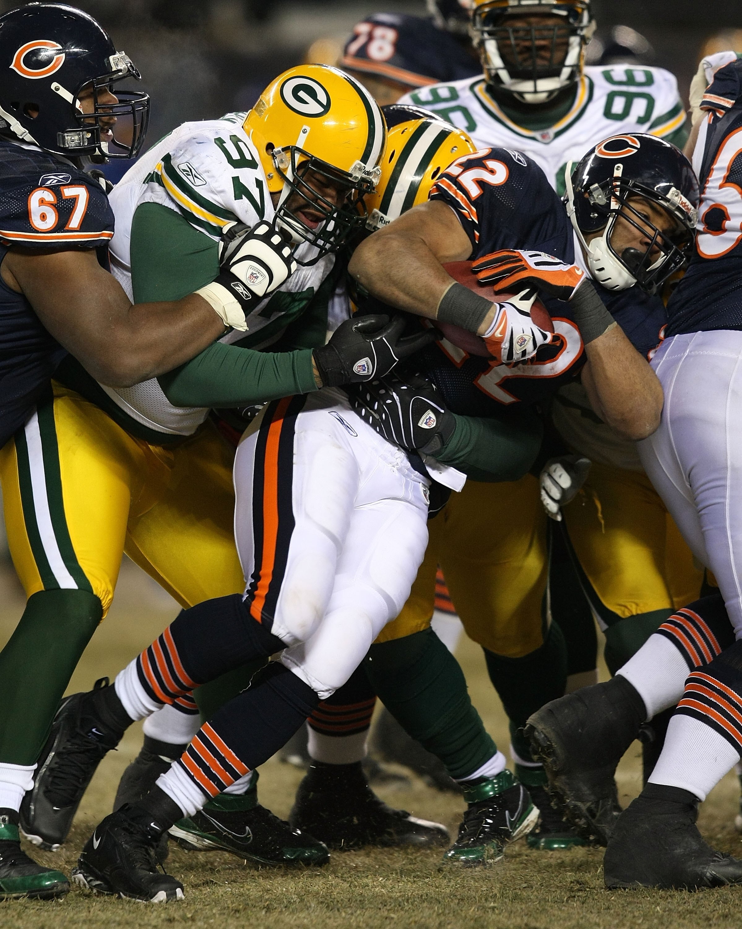 CHICAGO - DECEMBER 22: Matt Forte #22 of the Chicago Bears is tackled by Johnny Jolly #97 and Brandon Chillar #54 of the Green Bay Packers on December 22, 2008 at Soldier Field in Chicago, Illinois. The Bears defeated the Packers 20-17 in overtime.  (Phot