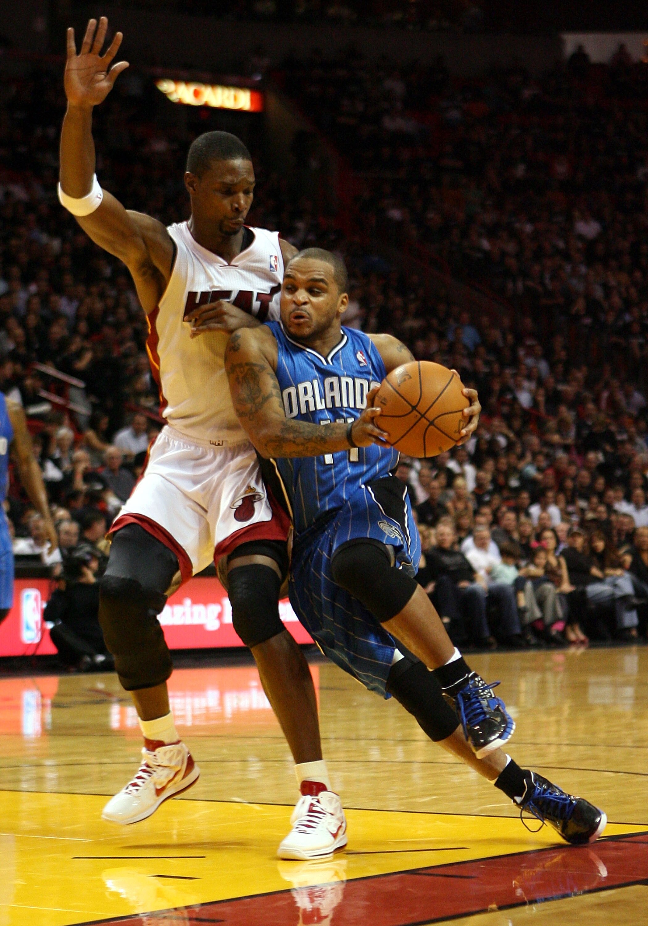 MIAMI - OCTOBER 29:  Forward Chris Bosh #1 of  the Miami Heat defends against guard Jameer Nelson #14 of the Orlando Magic at American Airlines Arena on October 29, 2010 in Miami, Florida.  NOTE TO USER: User expressly acknowledges and agrees that, by dow