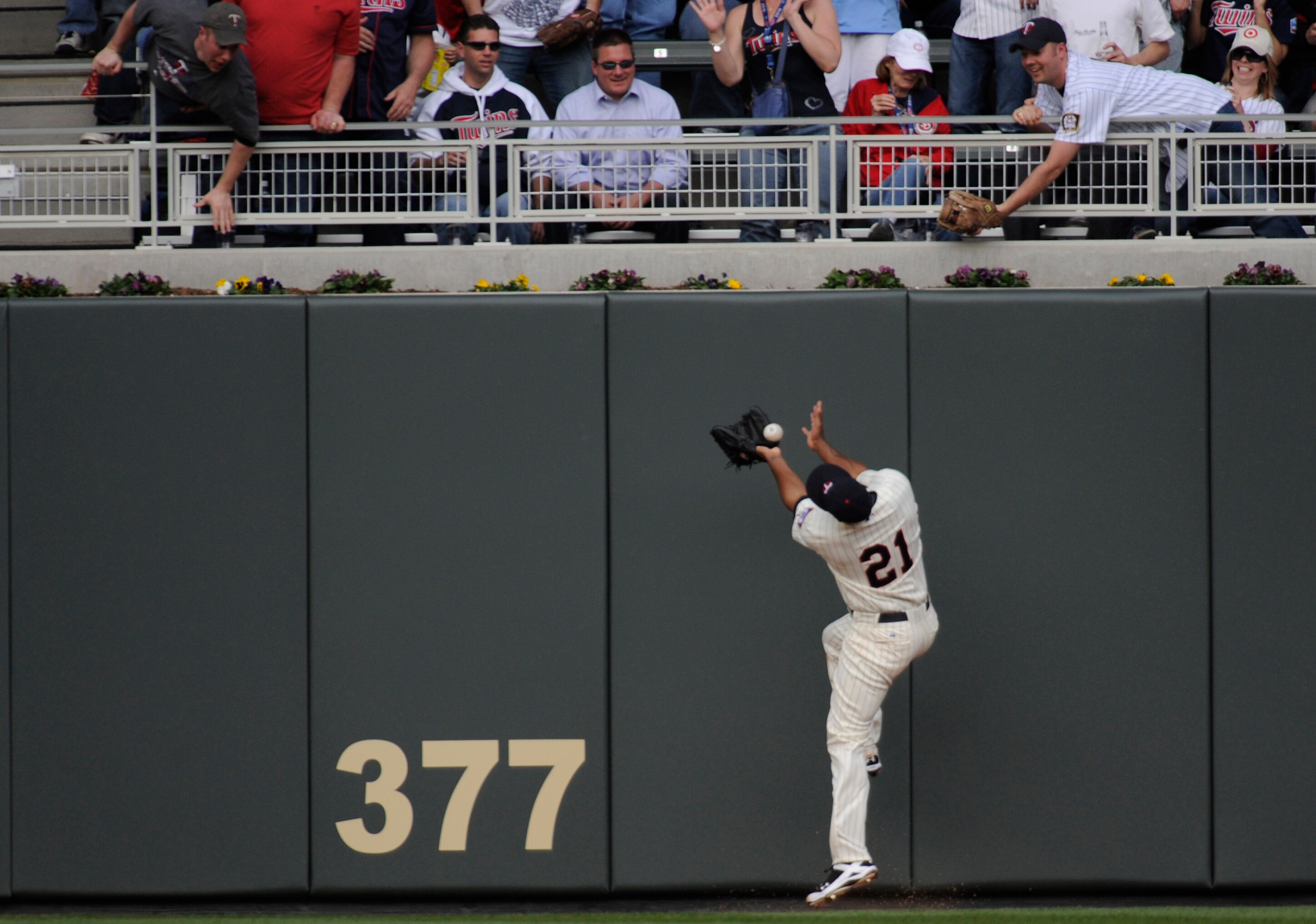 MINNESOTA, MN - APRIL 12: Delmon Young #21 of the Minnesota Twins bobbles the ball allowing Kevin Youkilis #20 of the Boston Red Sox to score in the fourth inning against the Boston Red Sox during the Twins home opener at Target Field on April 12, 2010 in