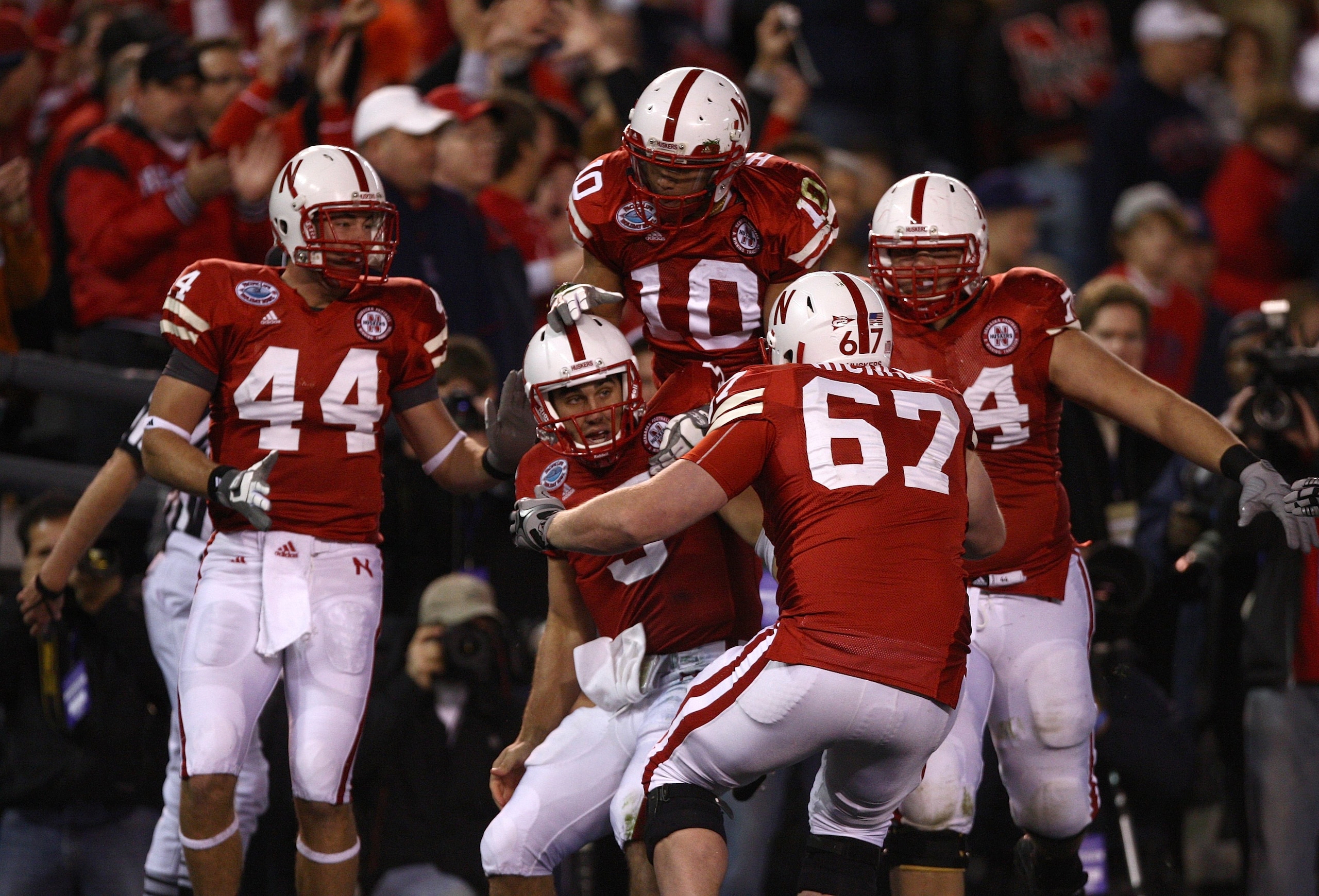 SAN DIEGO - DECEMBER 30:  Quarterback Zac Lee #5 of the University of Nebraska Cornhuskers is mobbed by teammates after scoring the first touchdown against the University of Arizona Wildcats during the Pacific Life Holiday Bowl on December 30, 2009 at Qua