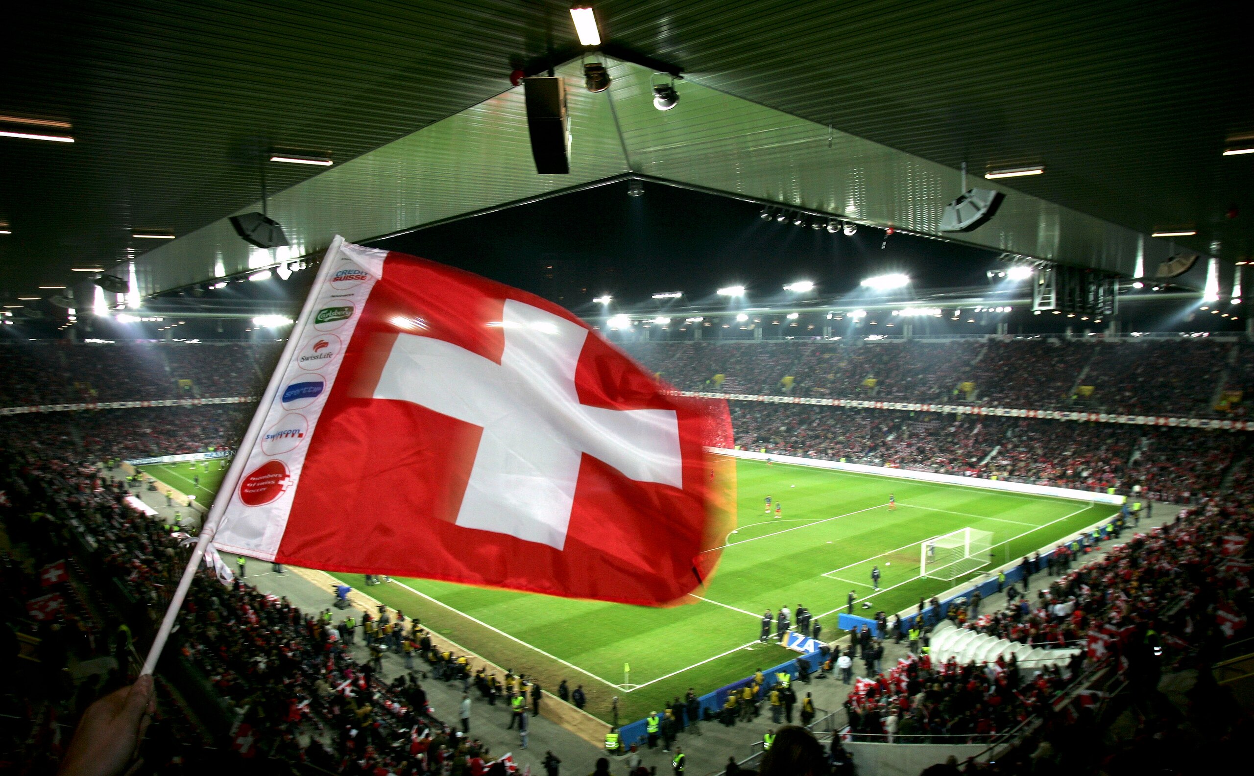BERN, SWITZERLAND - NOVEMBER 12:  A Swiss football fan waves his flag during The Football World Cup Qualification play-off  match between Switzerland and Turkey at Stad De Suisse on November 12, 2005 in Bern, Switzerland.  (Photo by Stuart Franklin/Getty