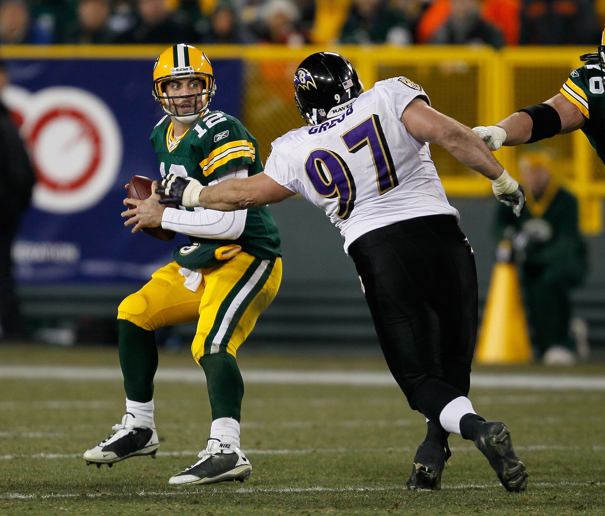 GREEN BAY, WI - DECEMBER 07: Aaron Rodgers #12 of the Green Bay Packers tries to escape from Kelly Gregg #97 of the Baltimore Ravens at Lambeau Field on December 7, 2009 in Green Bay, Wisconsin. The Packers defeated the Ravens 27-17. (Photo by Jonathan Da
