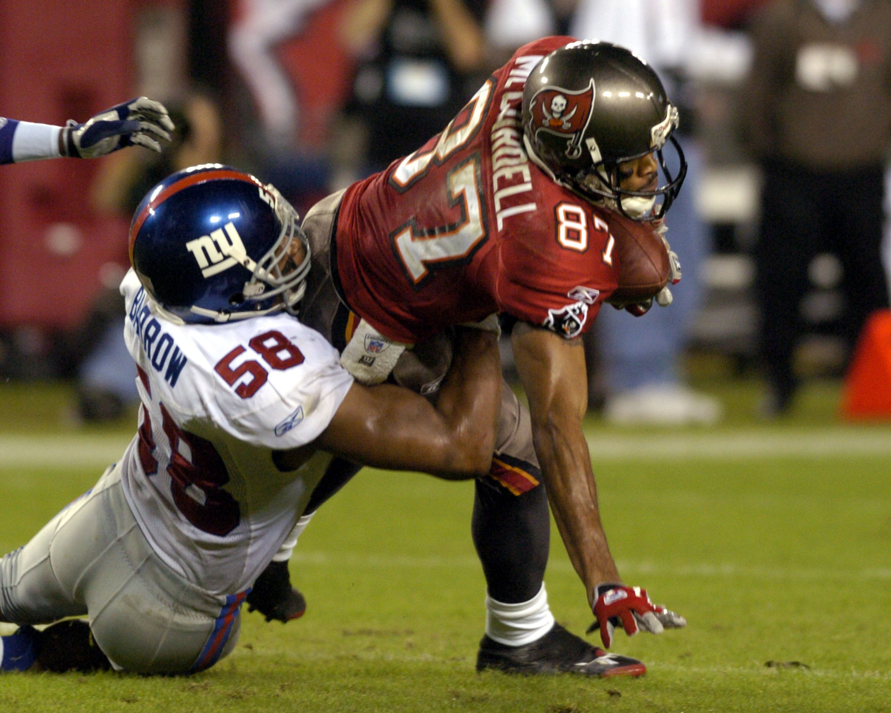 Tampa Bay Buccaneers wide receiver Keenan McCardell grabs a pass and faces a tackle by New York Giants linebacker Michael Barrow November 24, 2003 at Raymond James Stadium, Tampa. (Photo by Al Messerschmidt/Getty Images) Tampa Bay Buccaneers wide receiver Keenan McCardell grabs a pass and faces a tackle by New York Giants linebacker Michael Barrow November 24, 2003 at Raymond James Stadium, Tampa. (Photo by Al Messerschmidt/Getty Images)