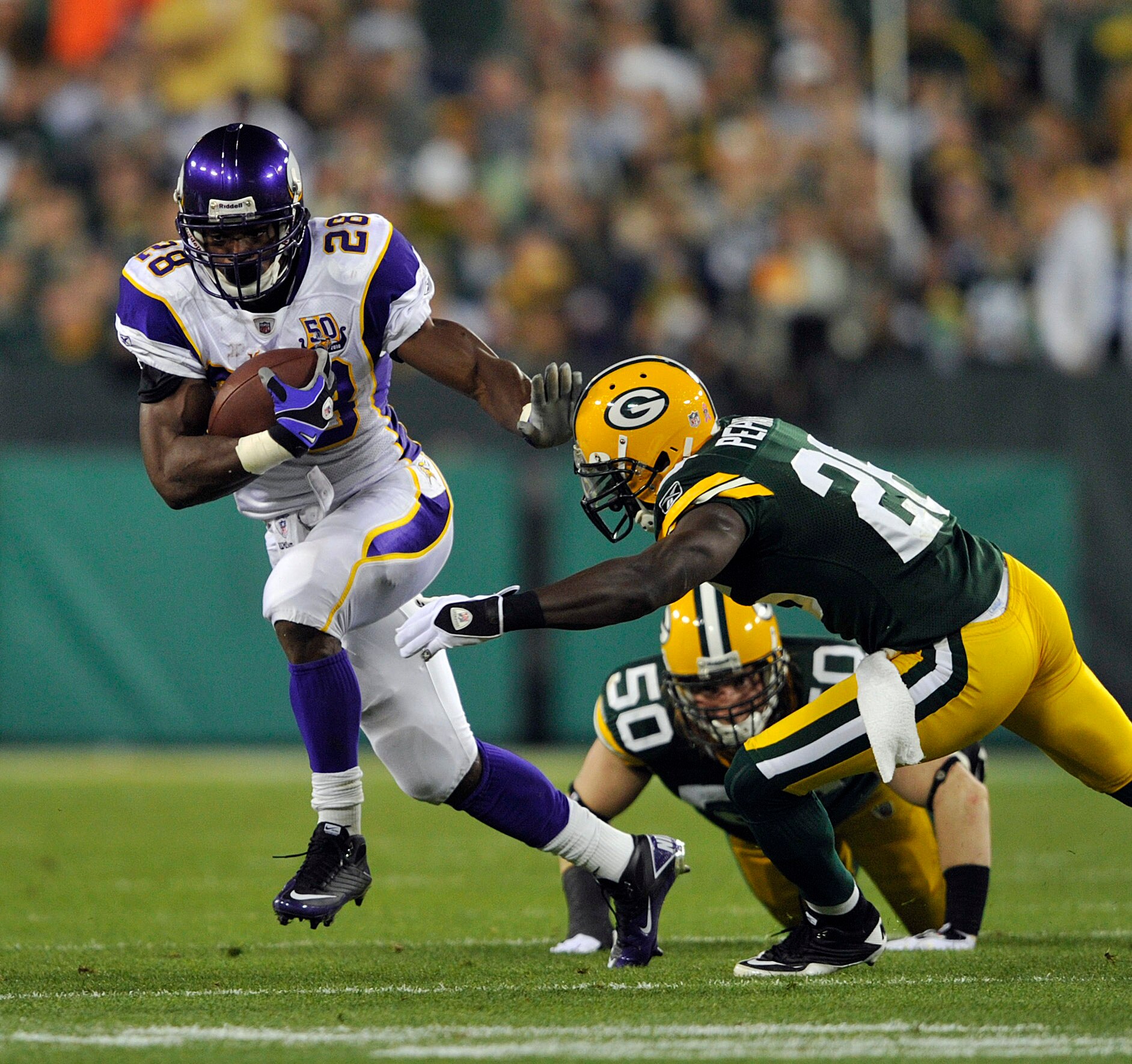 GREEN BAY, WI - OCTOBER 24:  Adrian Peterson #28 of the Minnesota Vikings runs upfield as Charlie Peprah #26 of the Green Bay Packers misses the tackle at Lambeau Field on October 24, 2010 in Green Bay, Wisconsin. (Photo by Jim Prisching/Getty Images)