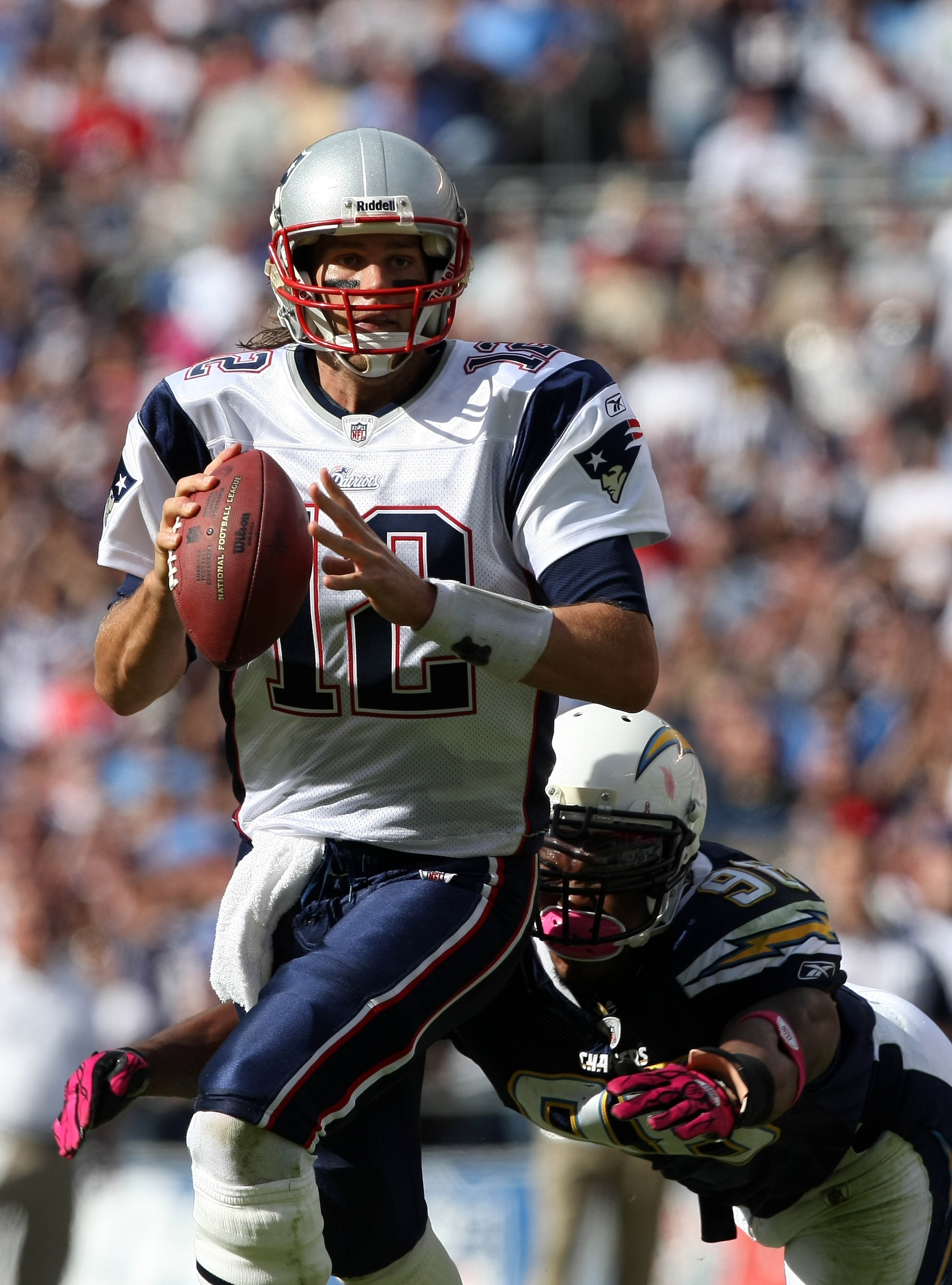 SAN DIEGO - OCTOBER 24:  Quarterback Tom Brady #12 of the New England scrambles with the ball against pressure from the pass rush of Antwan Barnes #98 of the San Diego Chargers during their NFL game on October 24, 2010 at Qualcomm Stadium in San Diego, Ca