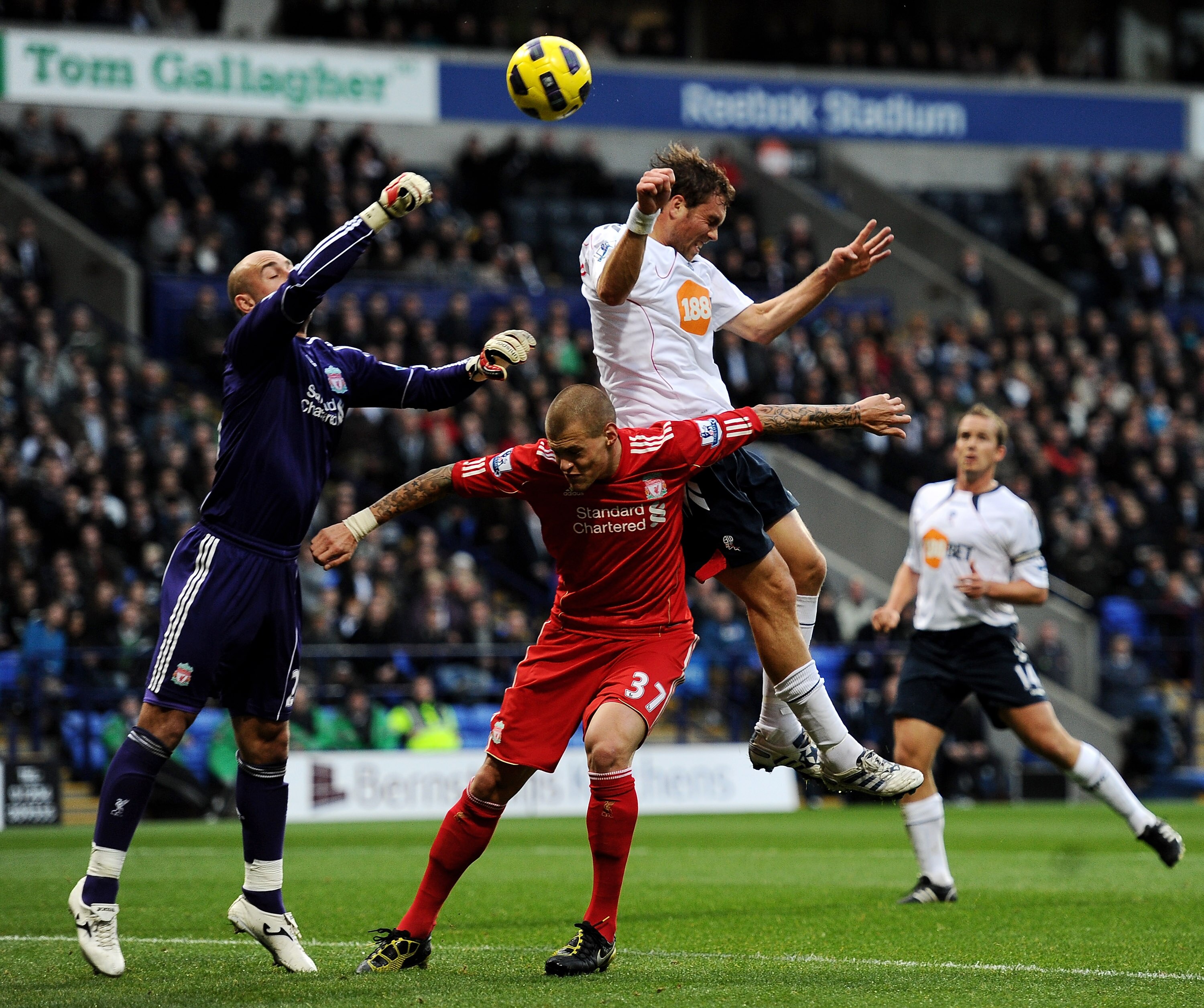 BOLTON, ENGLAND - OCTOBER 31:  Pepe Reina of Liverpool punches clear under pressure from Johan Elmander of Bolton Wanderers during the Barclays Premier League match between Bolton Wanderers and Liverpool at the Reebok Stadium on October 31, 2010 in Bolton