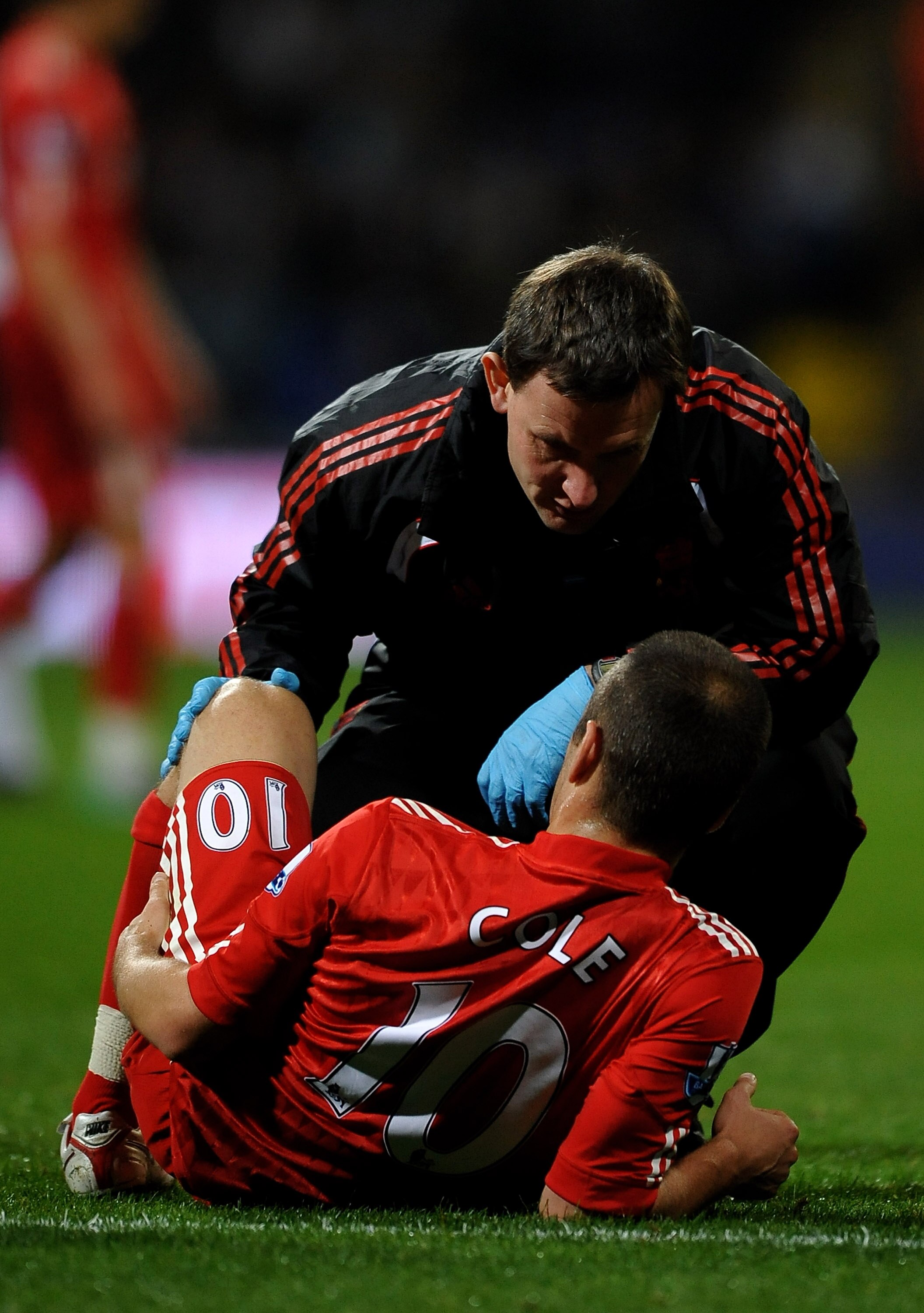 BOLTON, ENGLAND - OCTOBER 31:  Joe Cole of Liverpool receives treatment for an injury during the Barclays Premier League match between Bolton Wanderers and Liverpool at the Reebok Stadium on October 31, 2010 in Bolton, England.  (Photo by Laurence Griffit