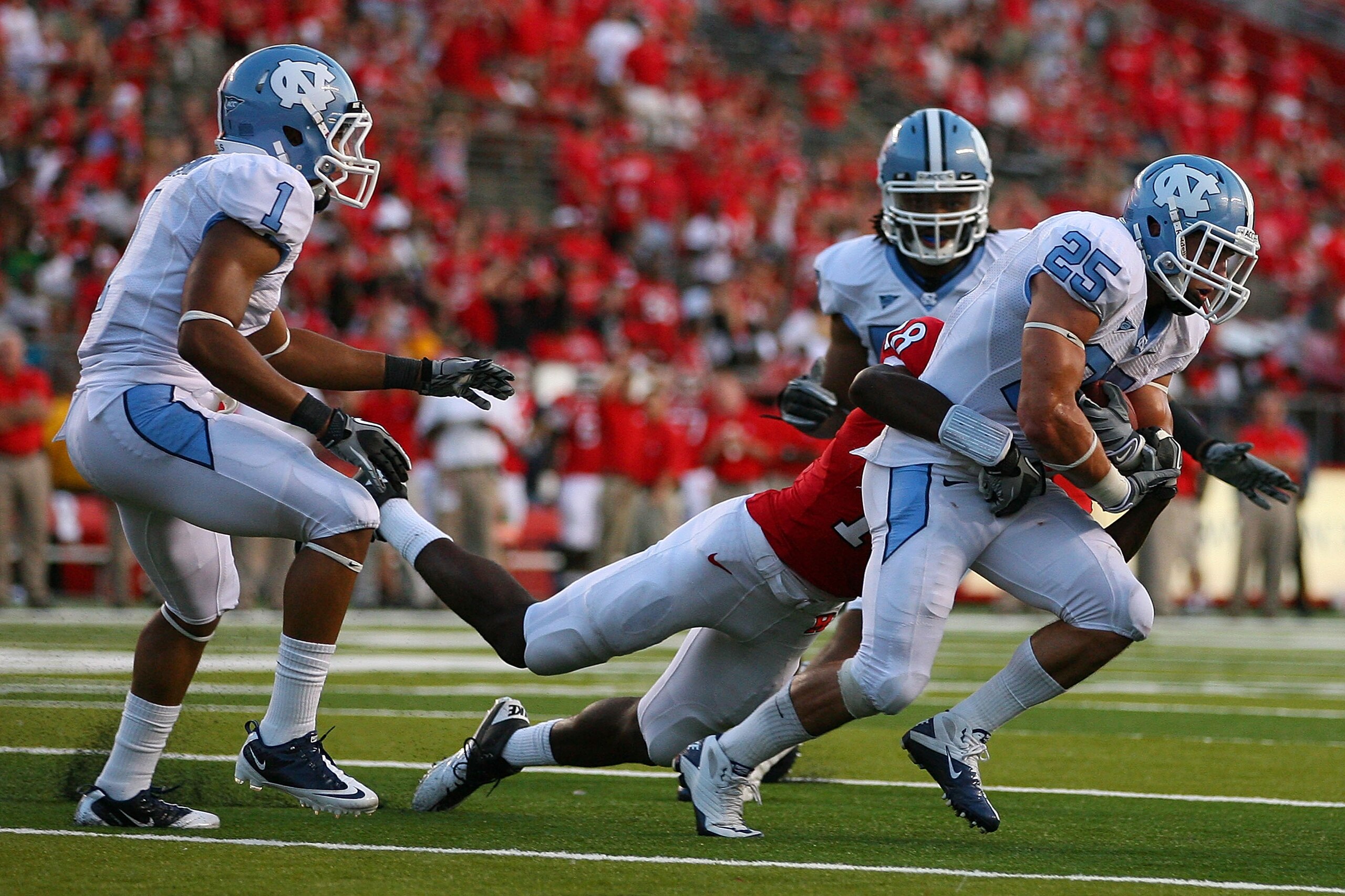 NEW BRUNSWICK, NJ - SEPTEMBER 25:  Matt Merletti #25 (R) of the North Carolina Tar Heels is tackled by Jeremy Deering #18 of the Rutgers Scarlet Knights after intercepting a pass intended for Deering in the fourth quarter at Rutgers Stadium on September 2