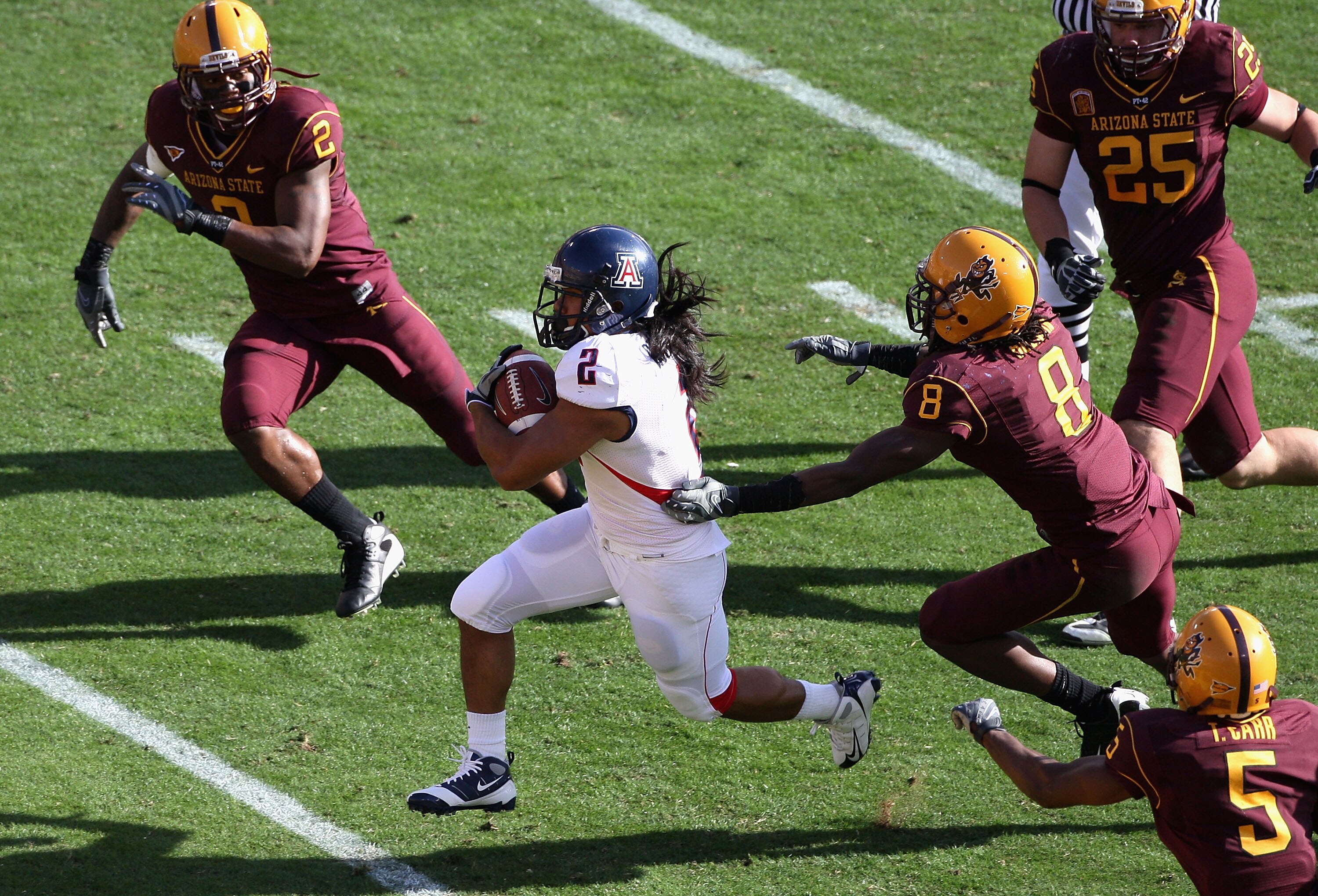 TEMPE, AZ - NOVEMBER 28:  Wide reciver Keola Antolin #2 of the Arizona Wildcats rushes for a 68 yard touchdown past Jarrell Holman #8 of the Arizona State Sun Devils during the college football game at Sun Devil Stadium on November 28, 2009 in Tempe, Ariz