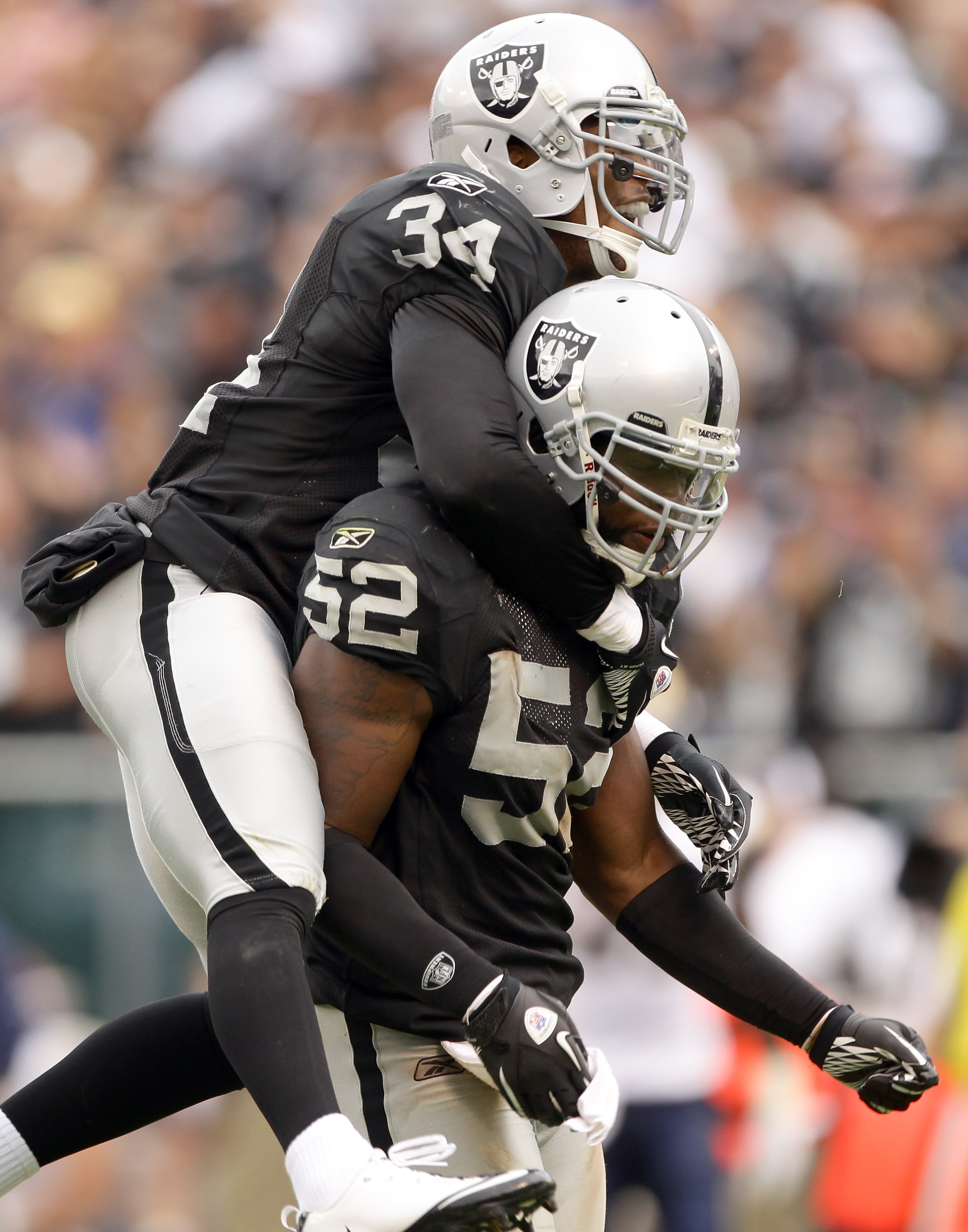 OAKLAND, CA - SEPTEMBER 19:  Mike Mitchell #34 and Quentin Groves #52 of the Oakland Raiders celebrate after a play during their game against the St. Louis Rams at the Oakland-Alameda County Coliseum on September 19, 2010 in Oakland, California.  (Photo b