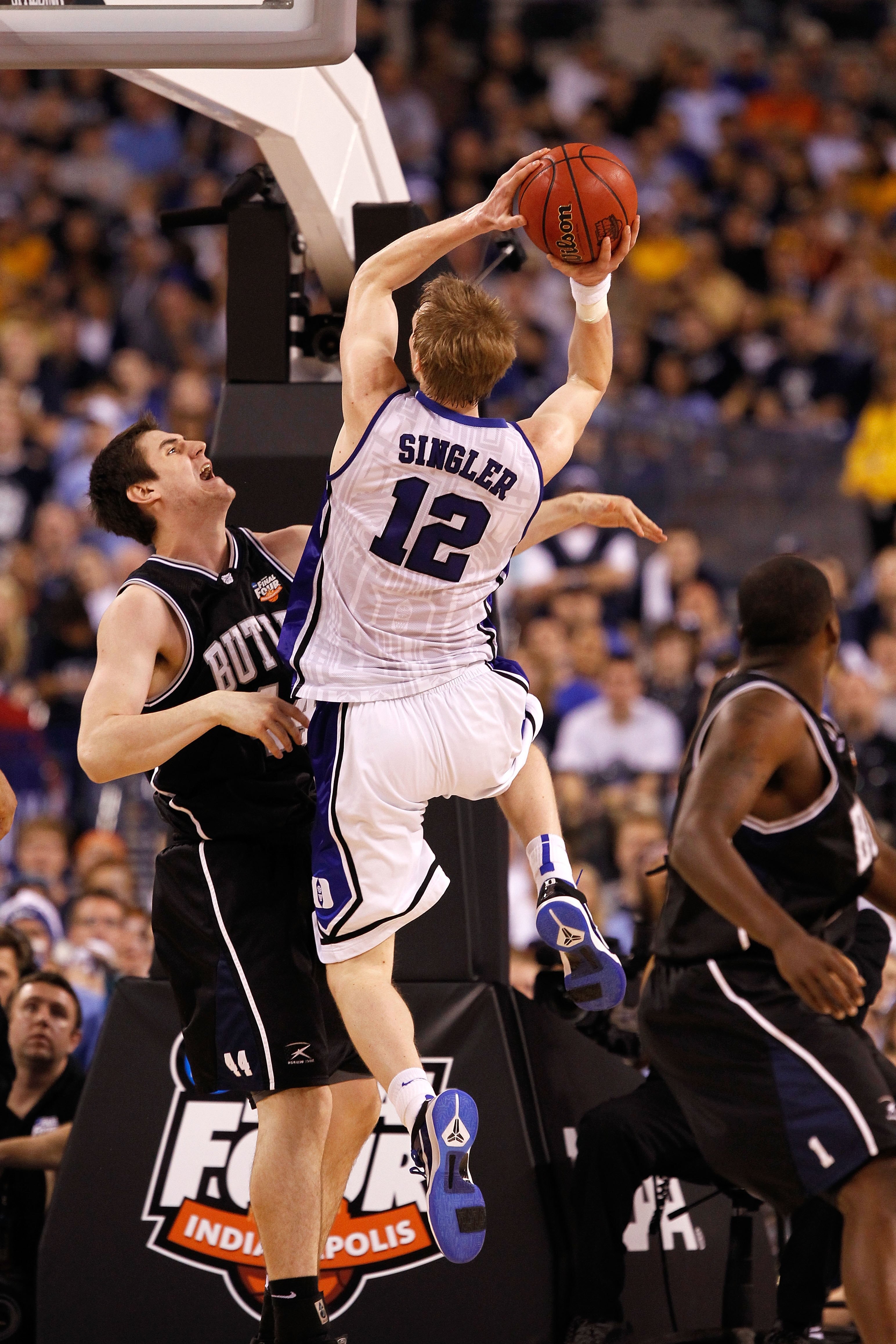 INDIANAPOLIS - APRIL 05:  Kyle Singler #12 of the Duke Blue Devils drives for a shot attempt against Andrew Smith #44 of the Butler Bulldogs during the 2010 NCAA Division I Men's Basketball National Championship game at Lucas Oil Stadium on April 5, 2010