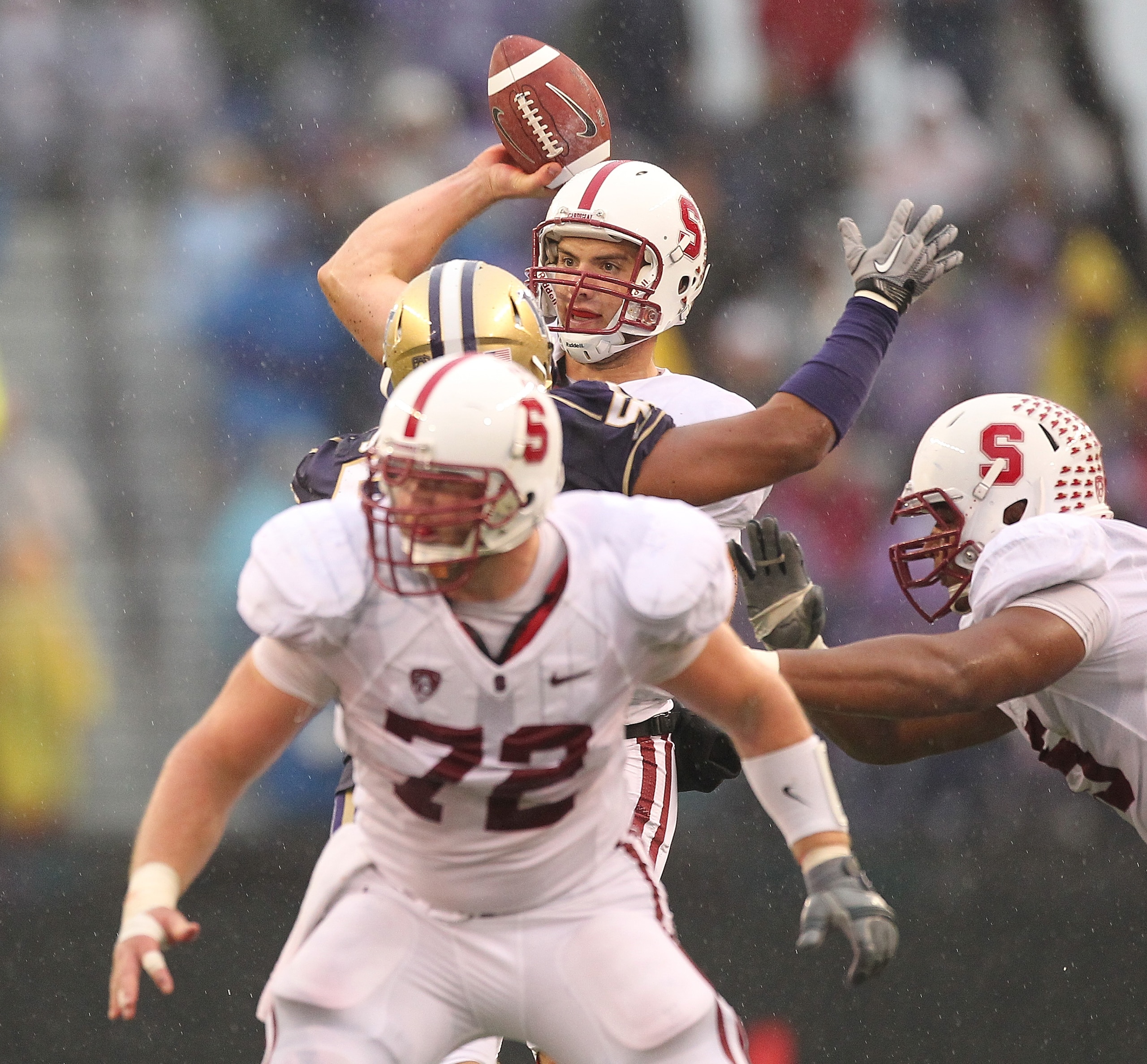 SEATTLE - OCTOBER 30:  Quarterback Andrew Luck #12 of the Stanford Cardinal passes under pressure from Hau'oli Jamora #52 of the Washington Huskies on October 30, 2010 at Husky Stadium in Seattle, Washington. (Photo by Otto Greule Jr/Getty Images)
