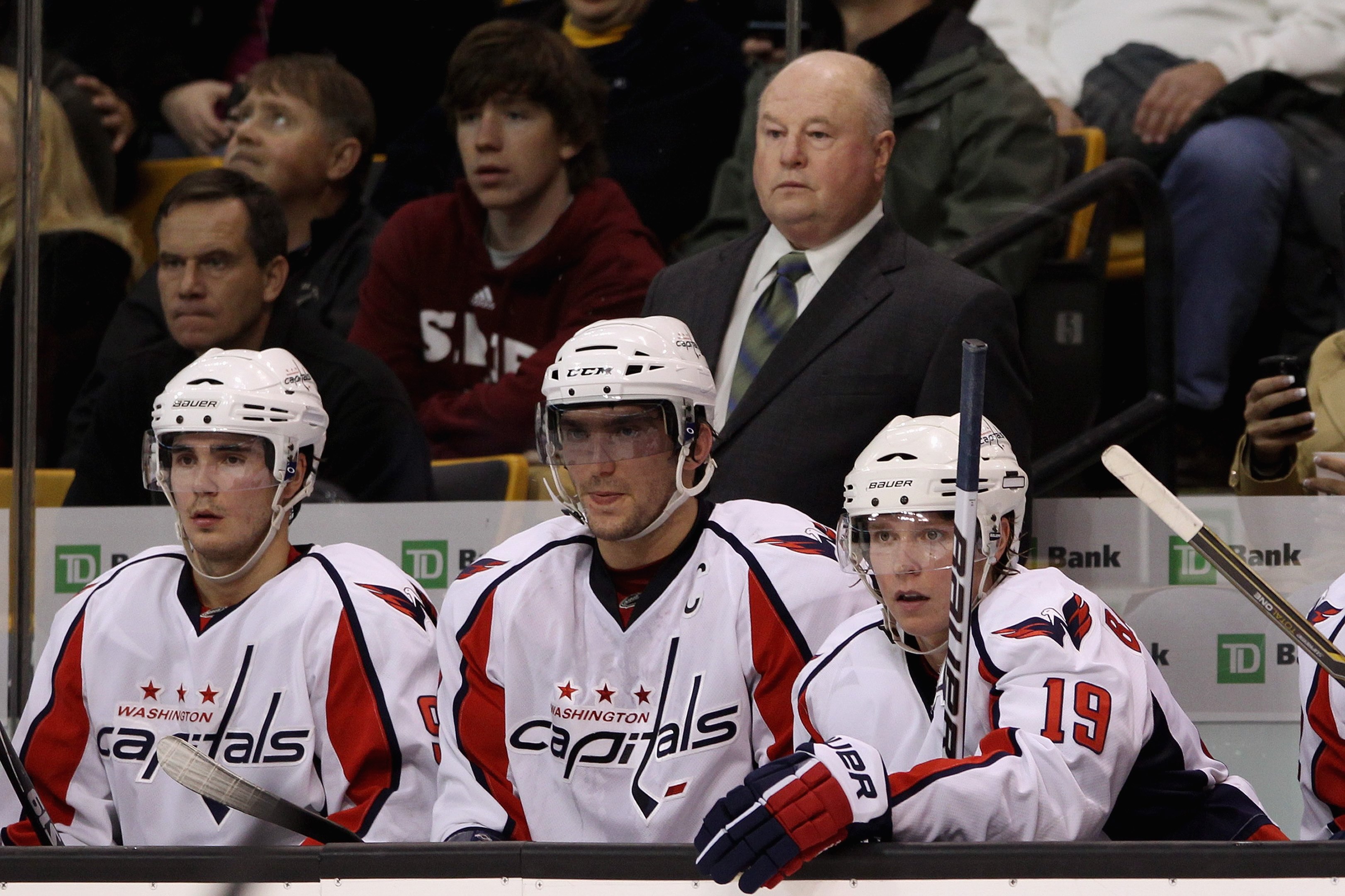 BOSTON - OCTOBER 21:  Head coach Bruce Boudreau of the Washington Capitals and (l-r) Marcus Johansson #90, Alex Ovechkin #8 and Nicklas Backstrom #19 look on from the bench against the Boston Bruins at the TD Garden on October 21, 2010 in Boston, Massachu
