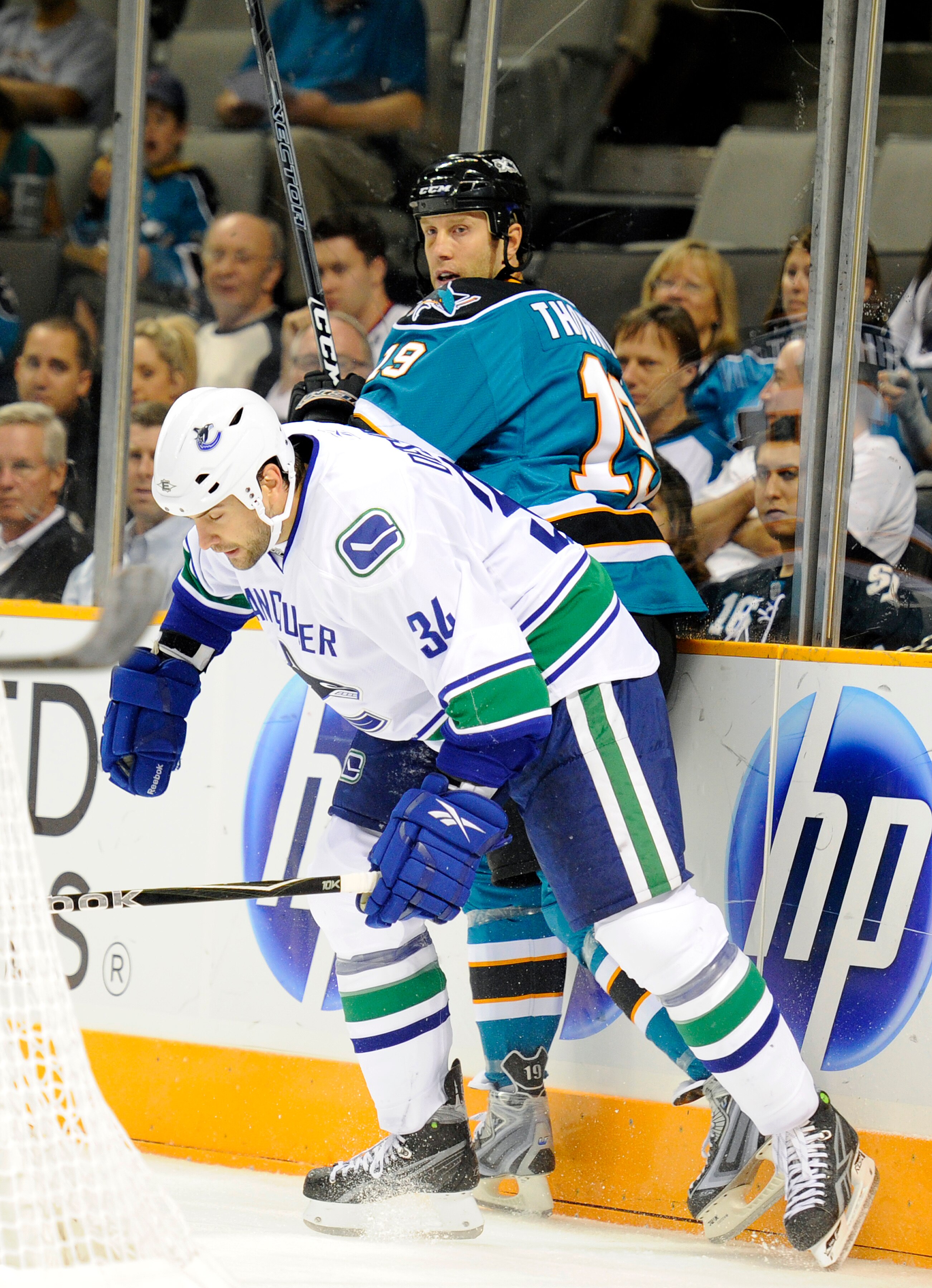 SAN JOSE, CA - SEPTEMBER 29: Guillaume Desbiens #43 of the Vancouver Canucks checks up against the board Joe Thornton #19 of the San Jose Sharks during their preseason game on September 29, 2010 at the HP Pavilion in San Jose, California. The Sharks won t